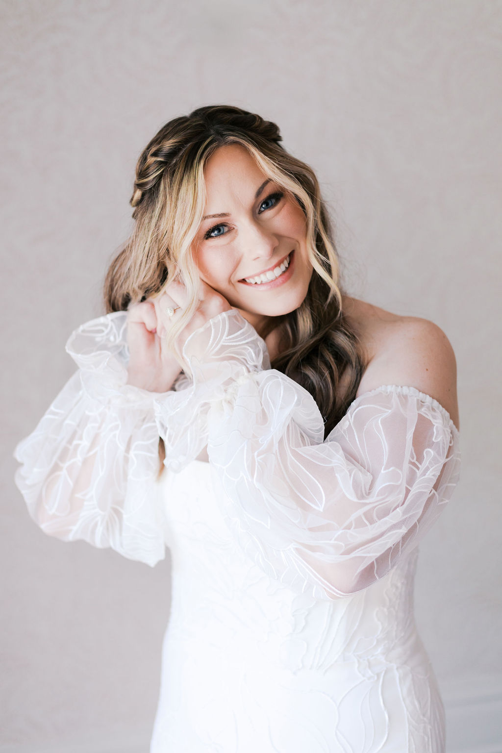 bride putting her earrings on looking into the camera
