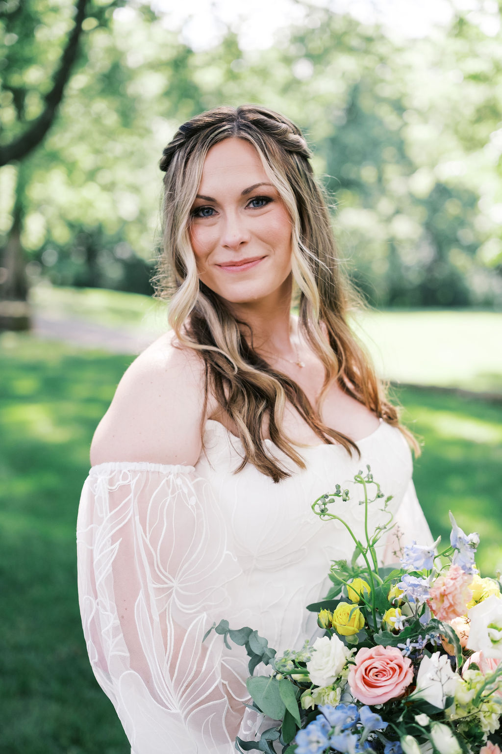 portrait of bride in off the shoulder dress with colorful bouquet