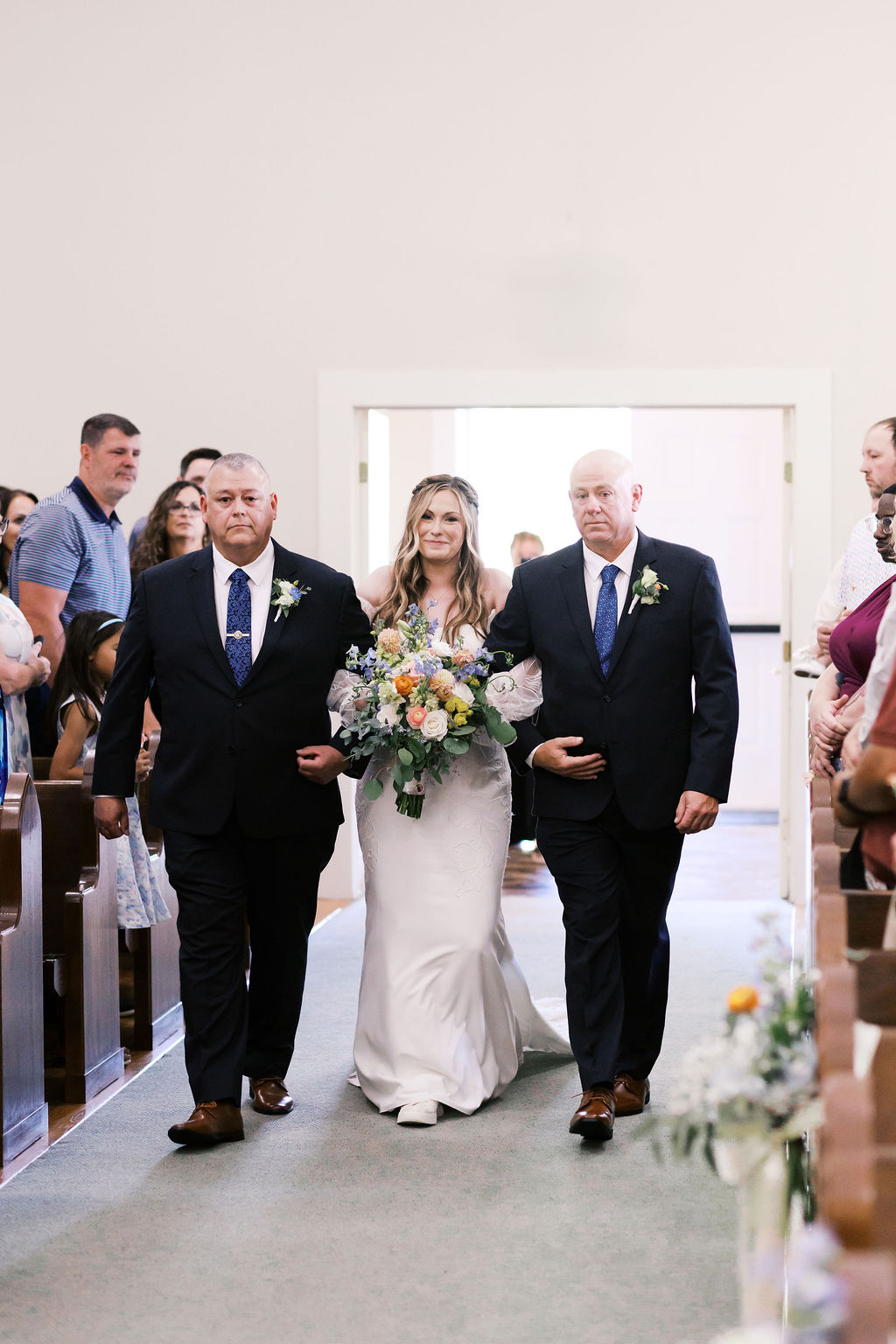 bride walking down the aisle with her two fathers at hawthorne house chapel