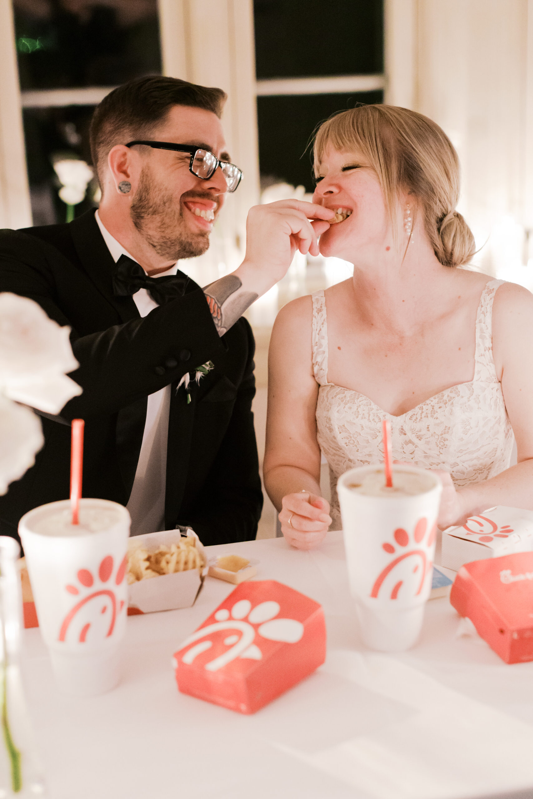 kansas city wedding at the simpson house with white roses and candle lit dinner feeding each other chick fila