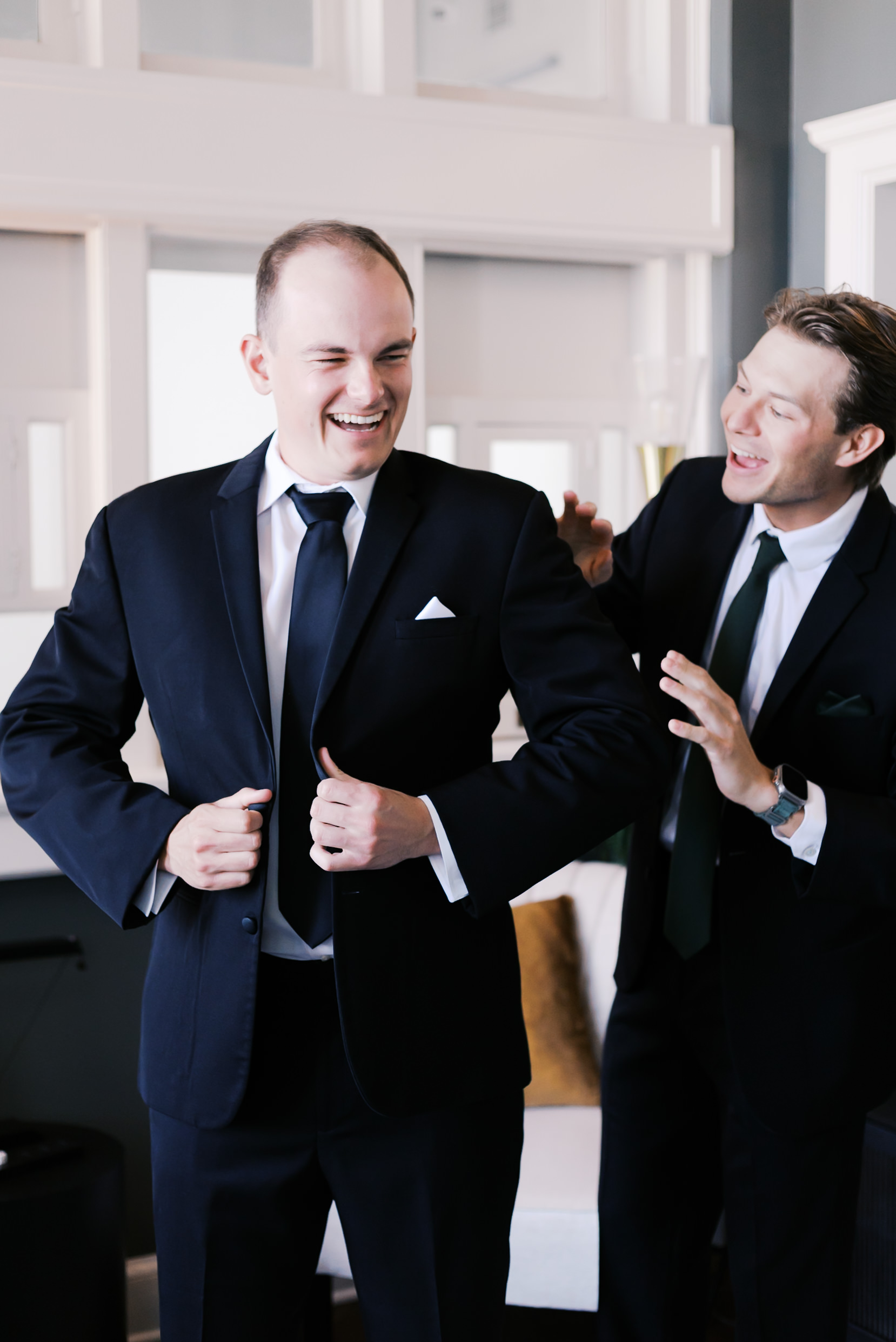 Groom and groomsmen adjusting their jacket