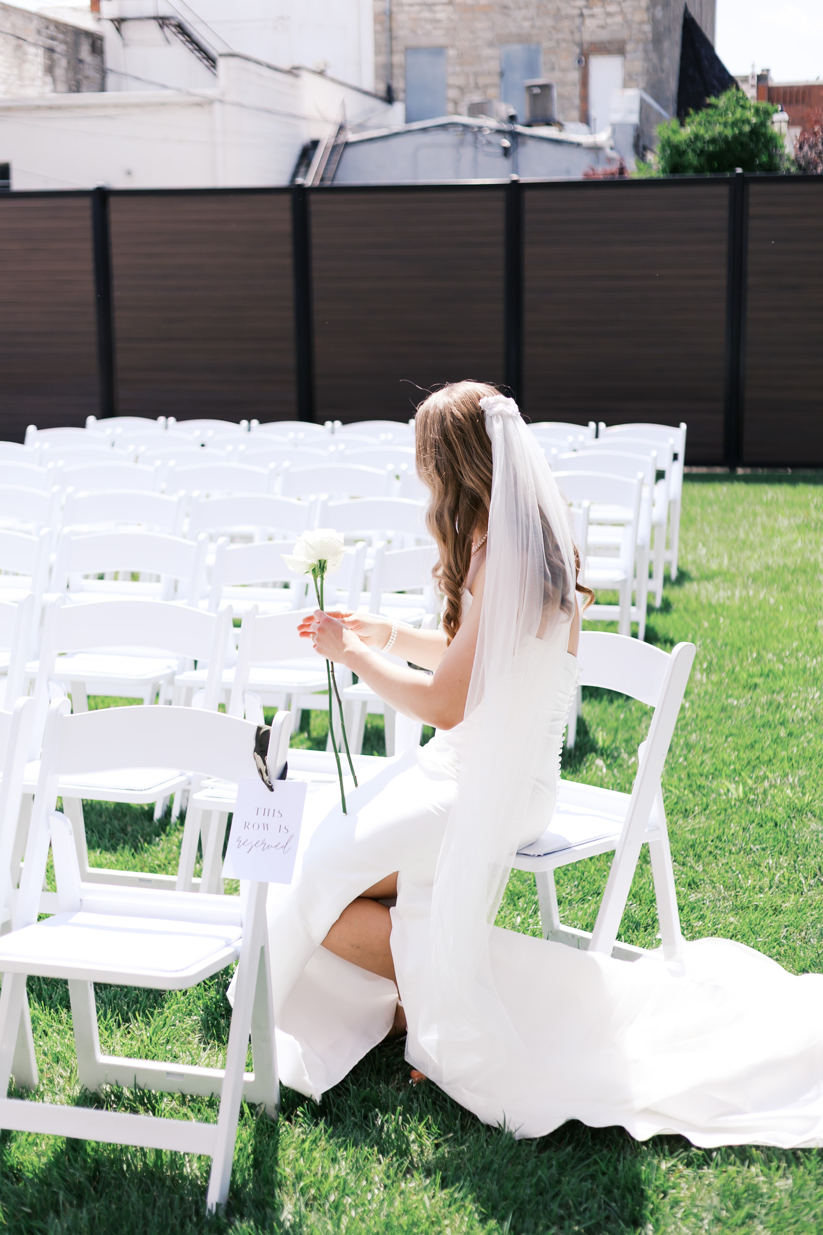 Bride placing a flower on a ceremony chair