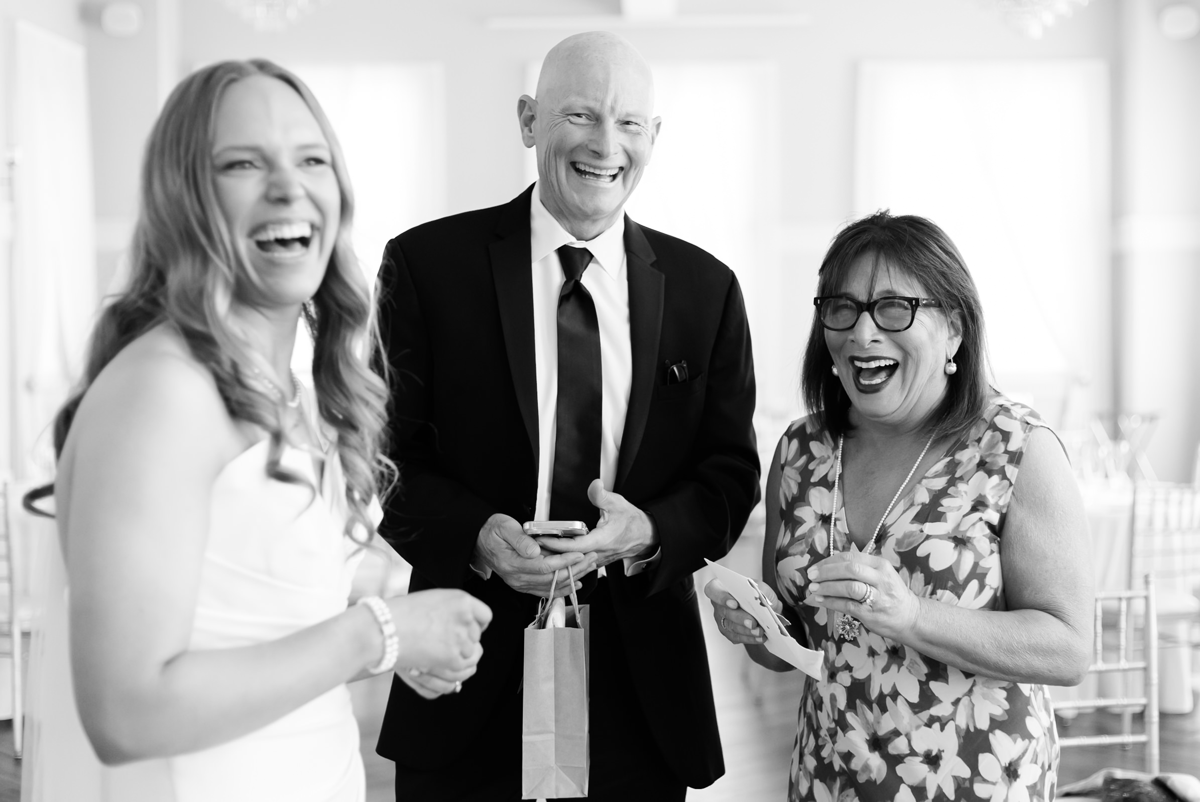 Bride laughing with a couple in black and white