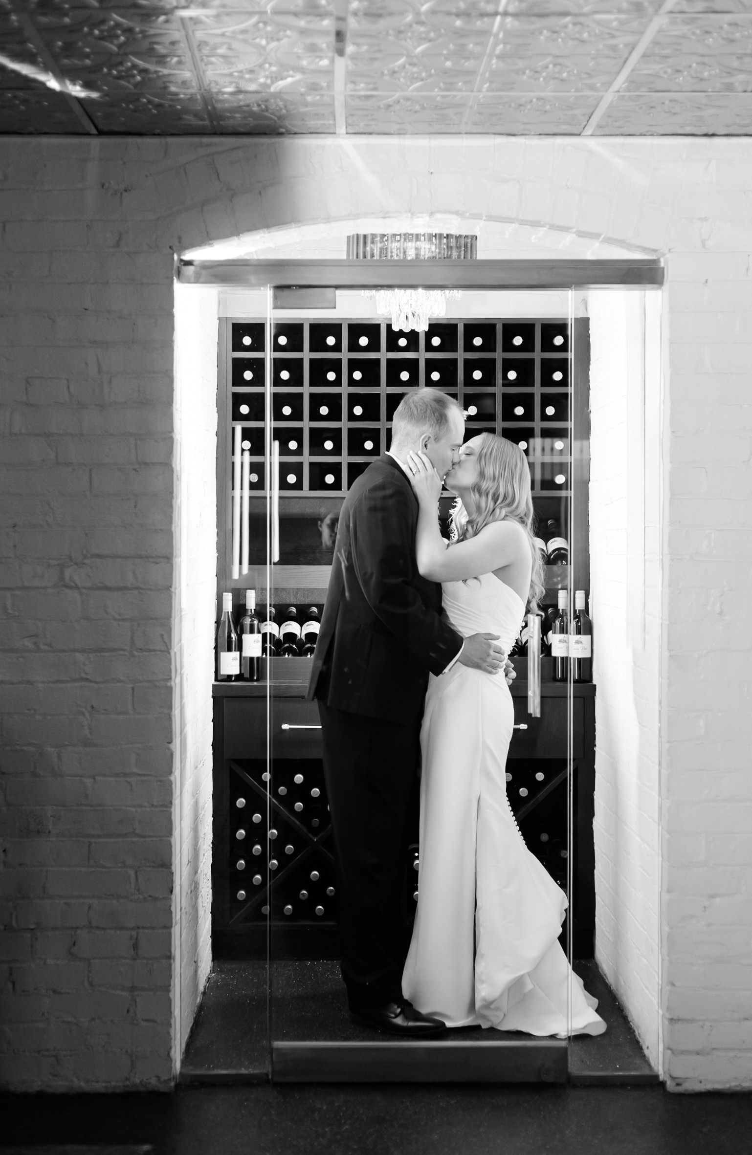 brid and groom kissing in the wine cellar