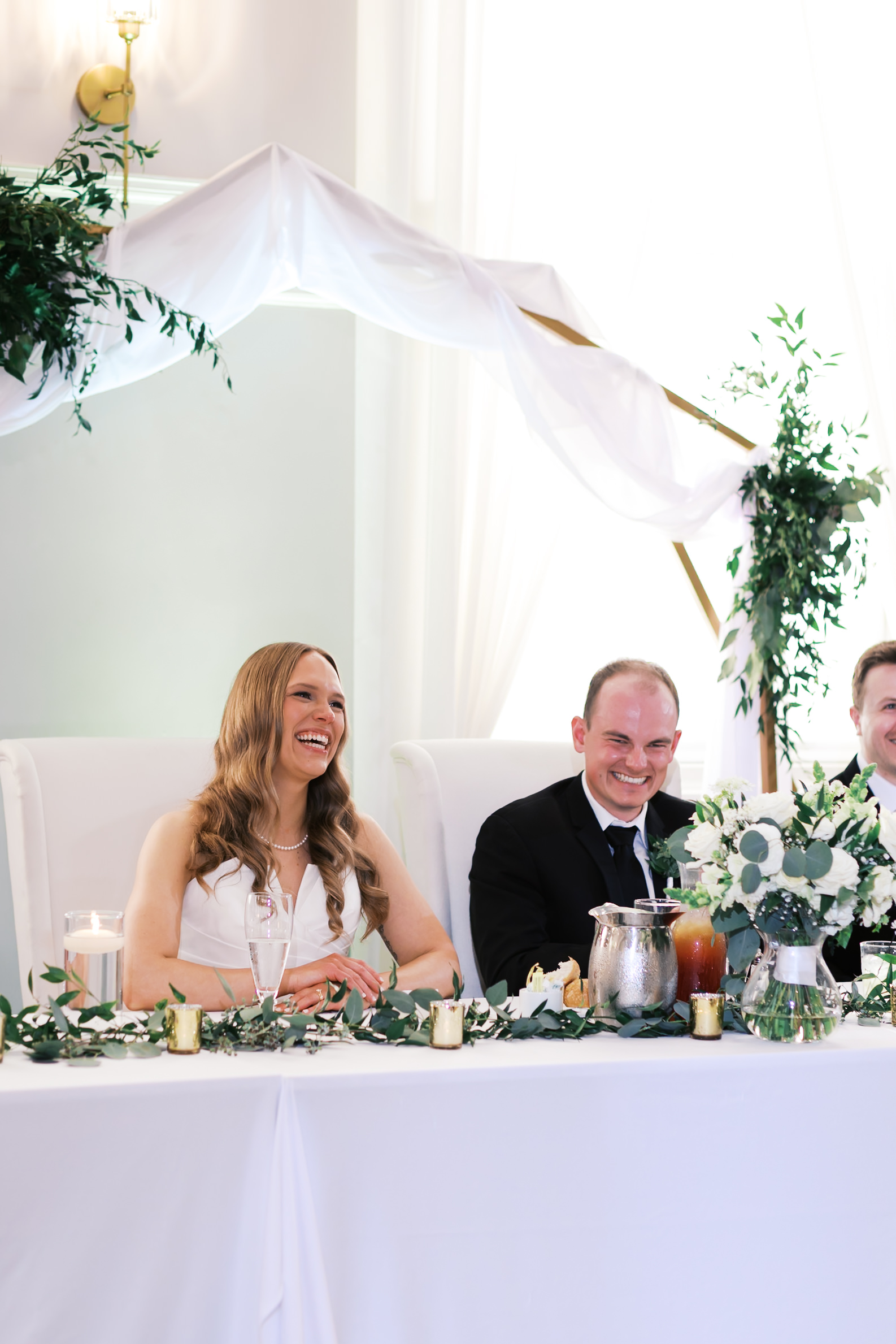 bride and groom smiling at head table