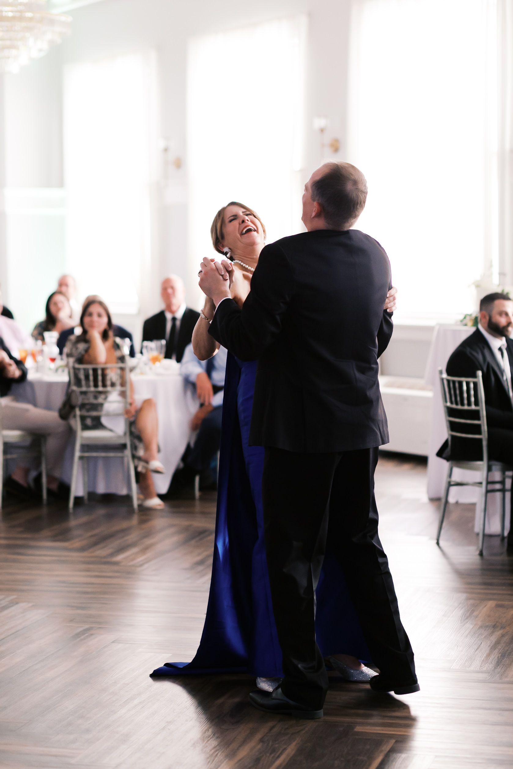 groom and mother of the bride laughing during their dance