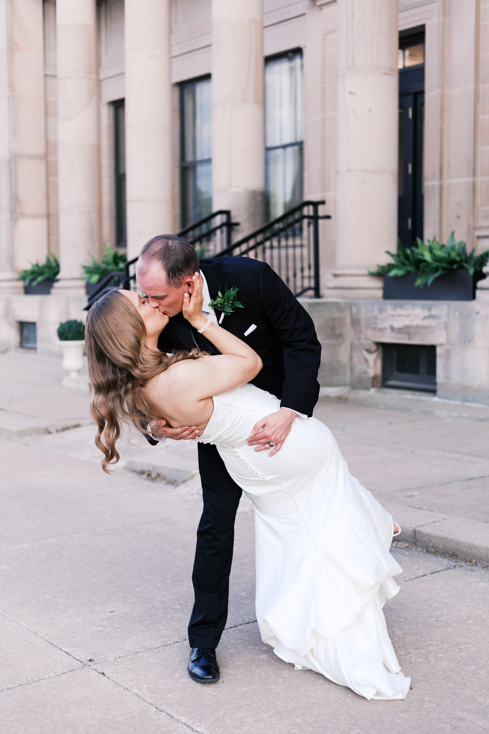 groom dipping and kissing bride outside the Lincoln Event Space