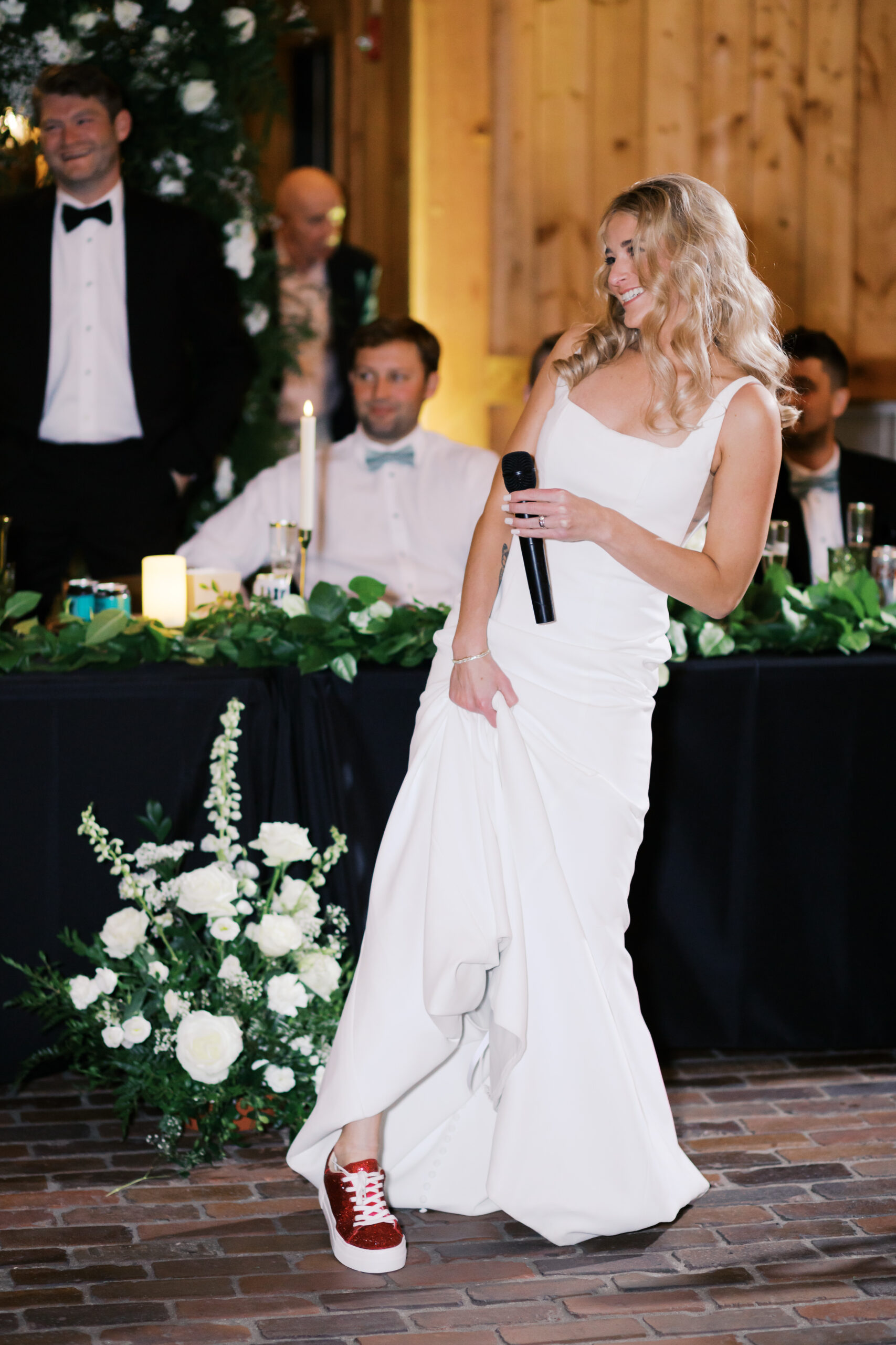 Bride holding microphone and showing off red sneakers