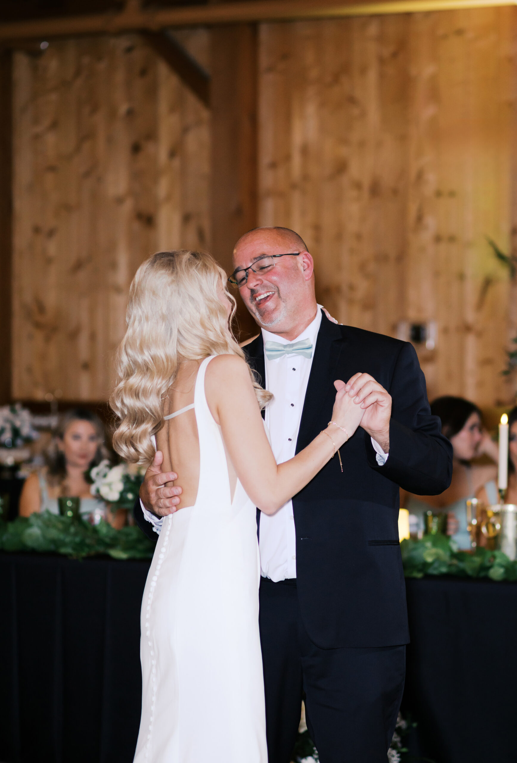 Father of the bride smiling at the bride during their dance