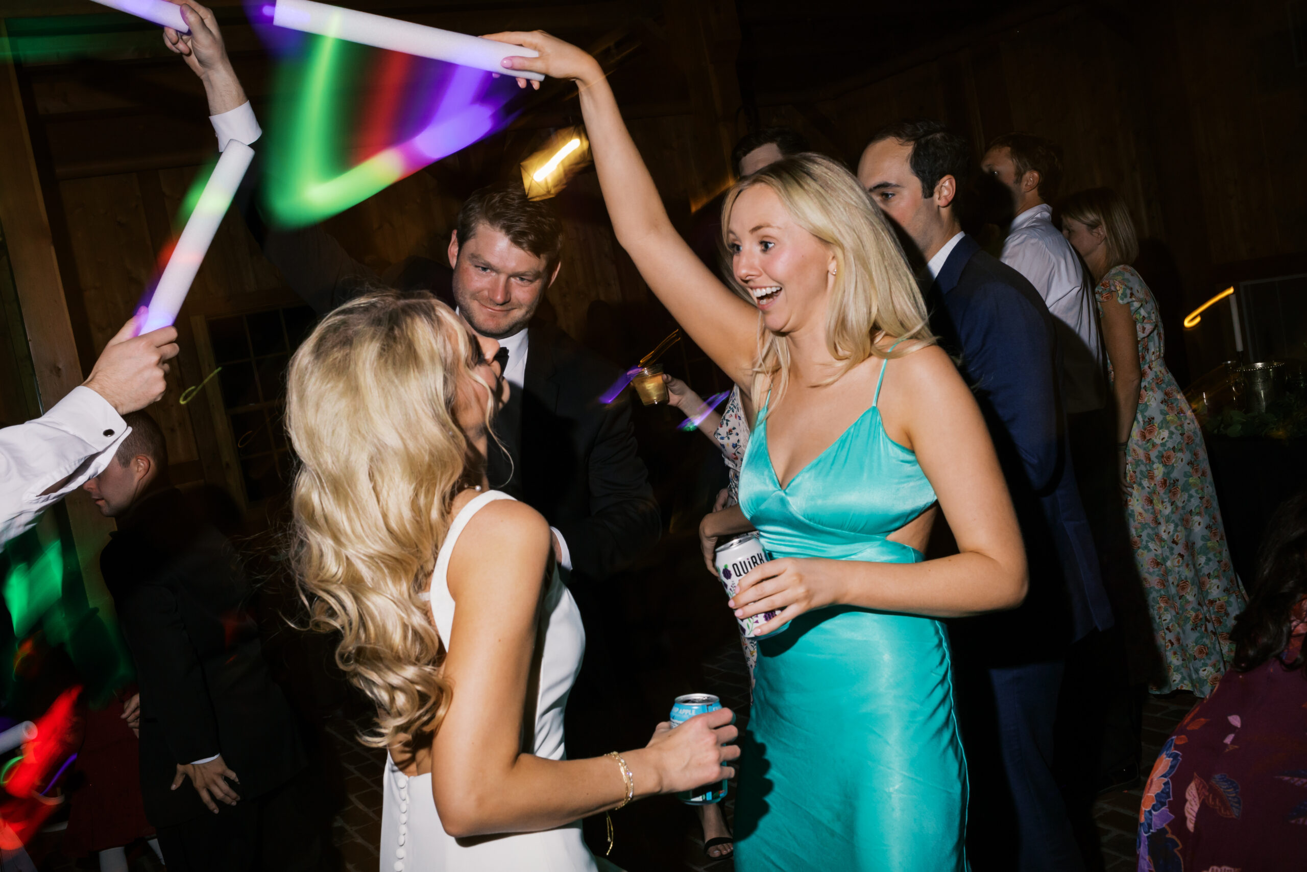 Bride and guest in a turquoise dress dancing