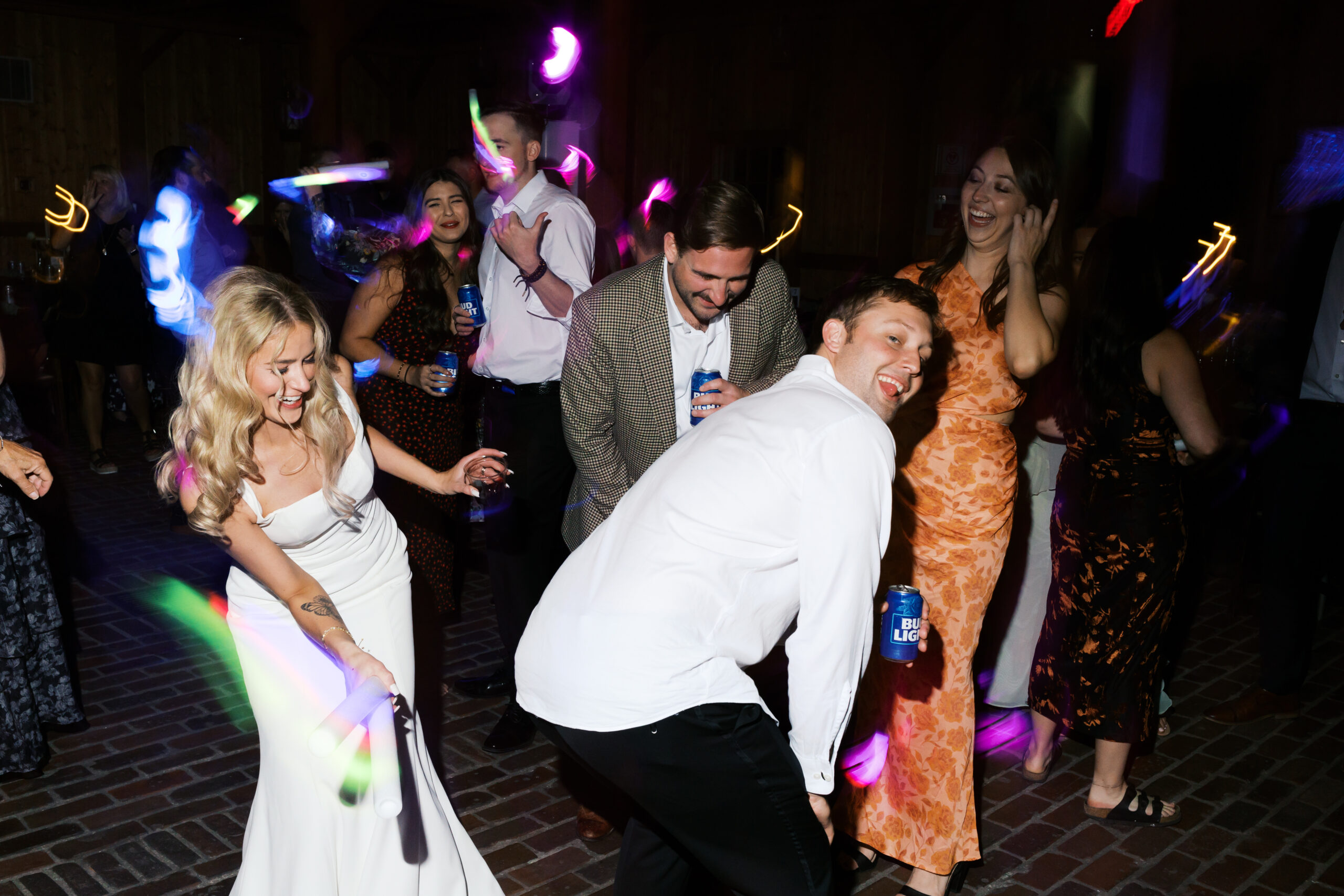 Bride dancing with friends surrounded by glowsticks