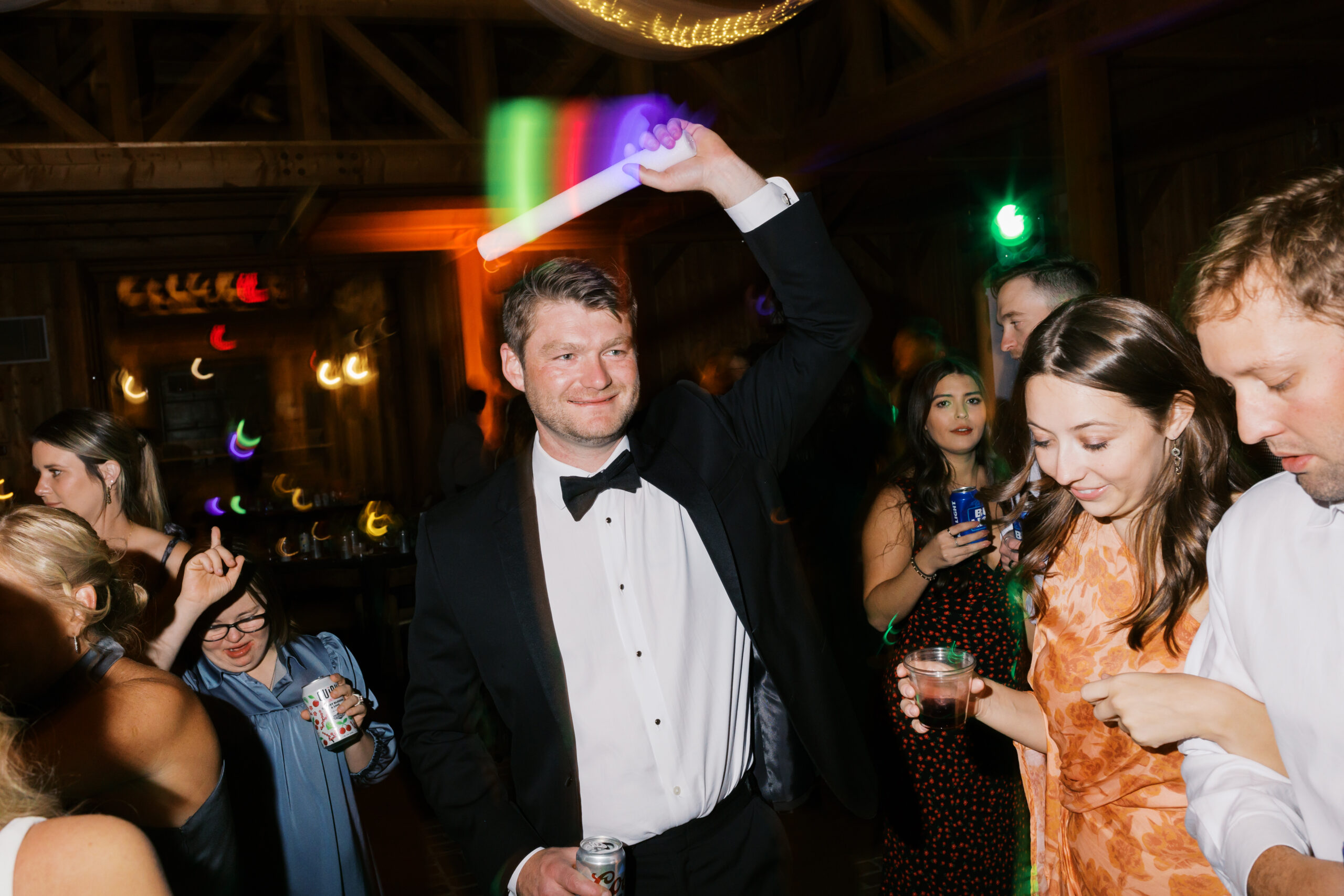 Groom dancing with light stick at reception