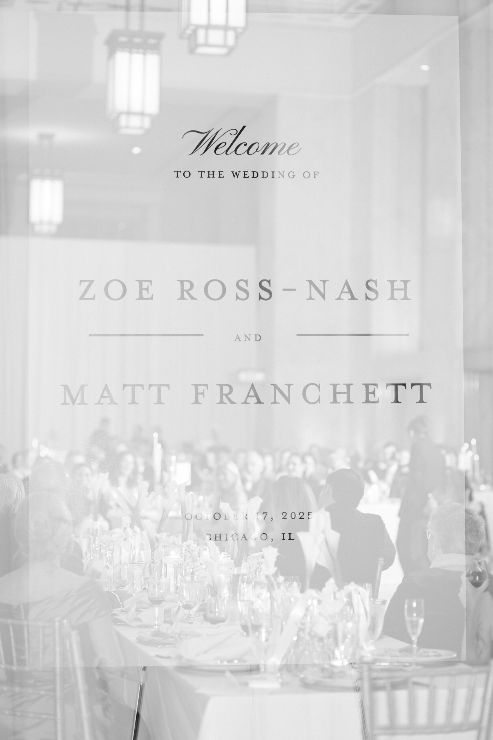 Clear acrylic wedding welcome sign for Zoe Ross-Nash and Matt Franchett, with guests seated at reception tables at The Old Post Office in Chicago.