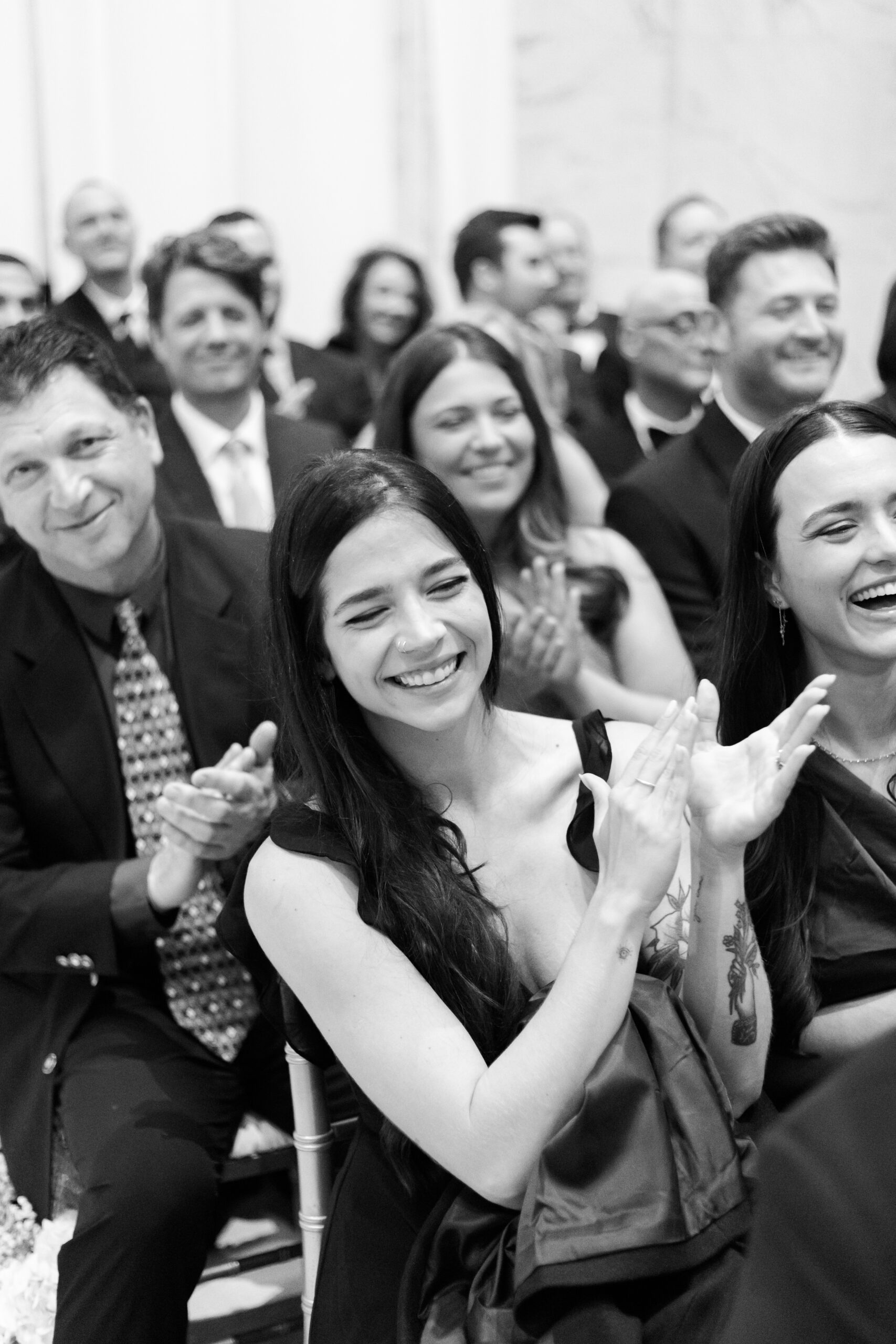Black and white photo of guests smiling and clapping