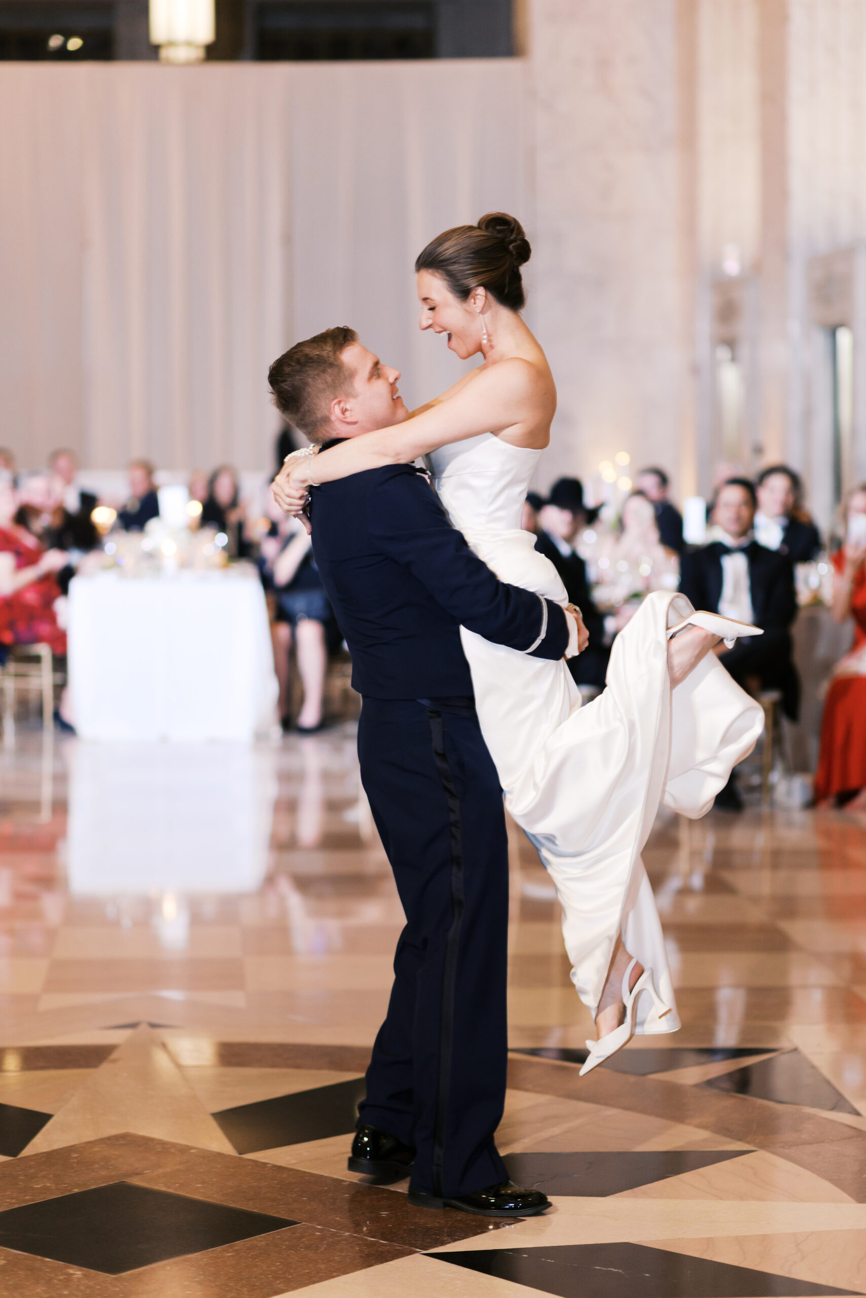 Groom picks up bride on the dance floor and she looks at him smiling