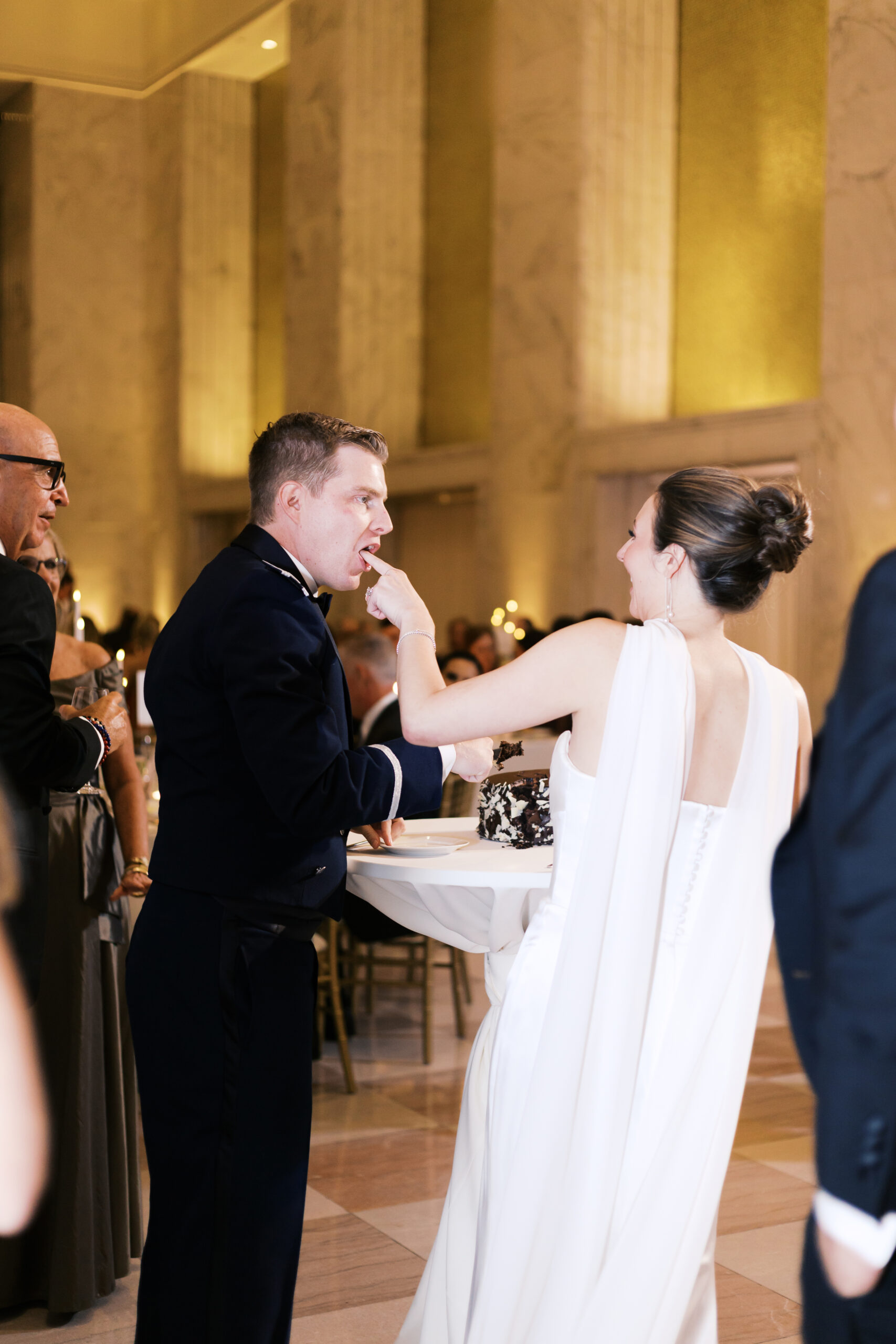 Bride sticking her finger in the grooms mouth after the cake cutting