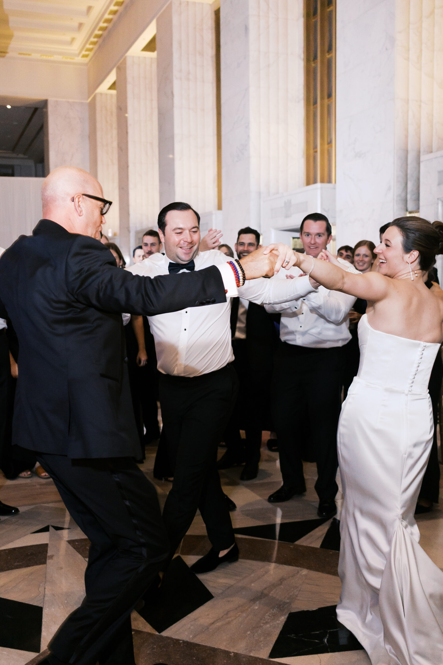 The bride and her father dancing at the reception with a group of guests.