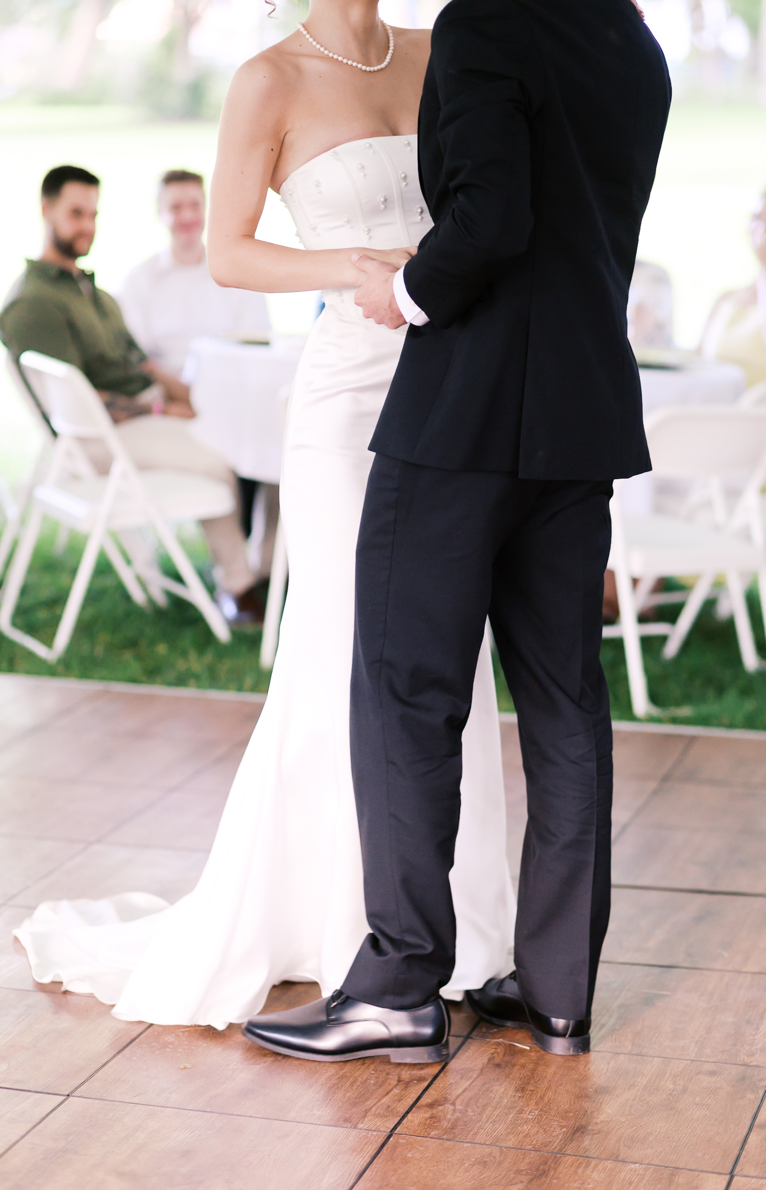 Bride and groom holding hands on the reception dance floor.