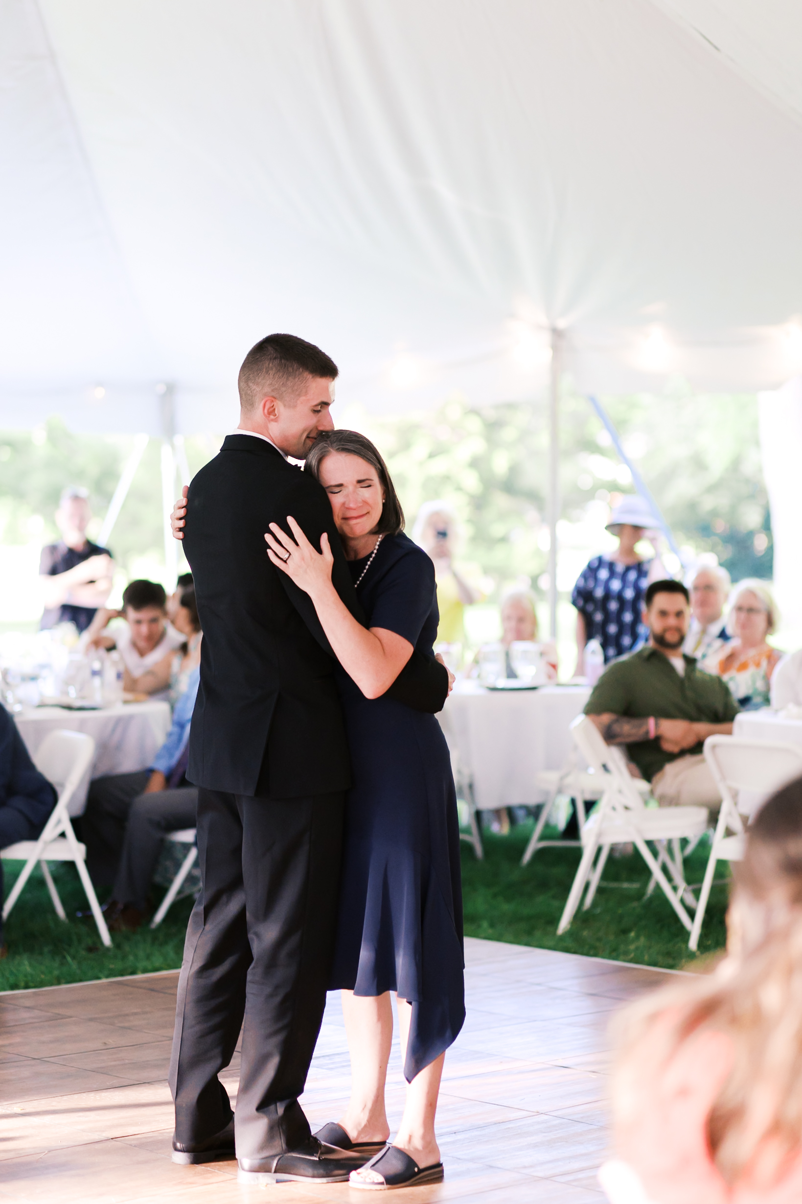 Groom and his mother hugging as they share a dance on the dance floor.