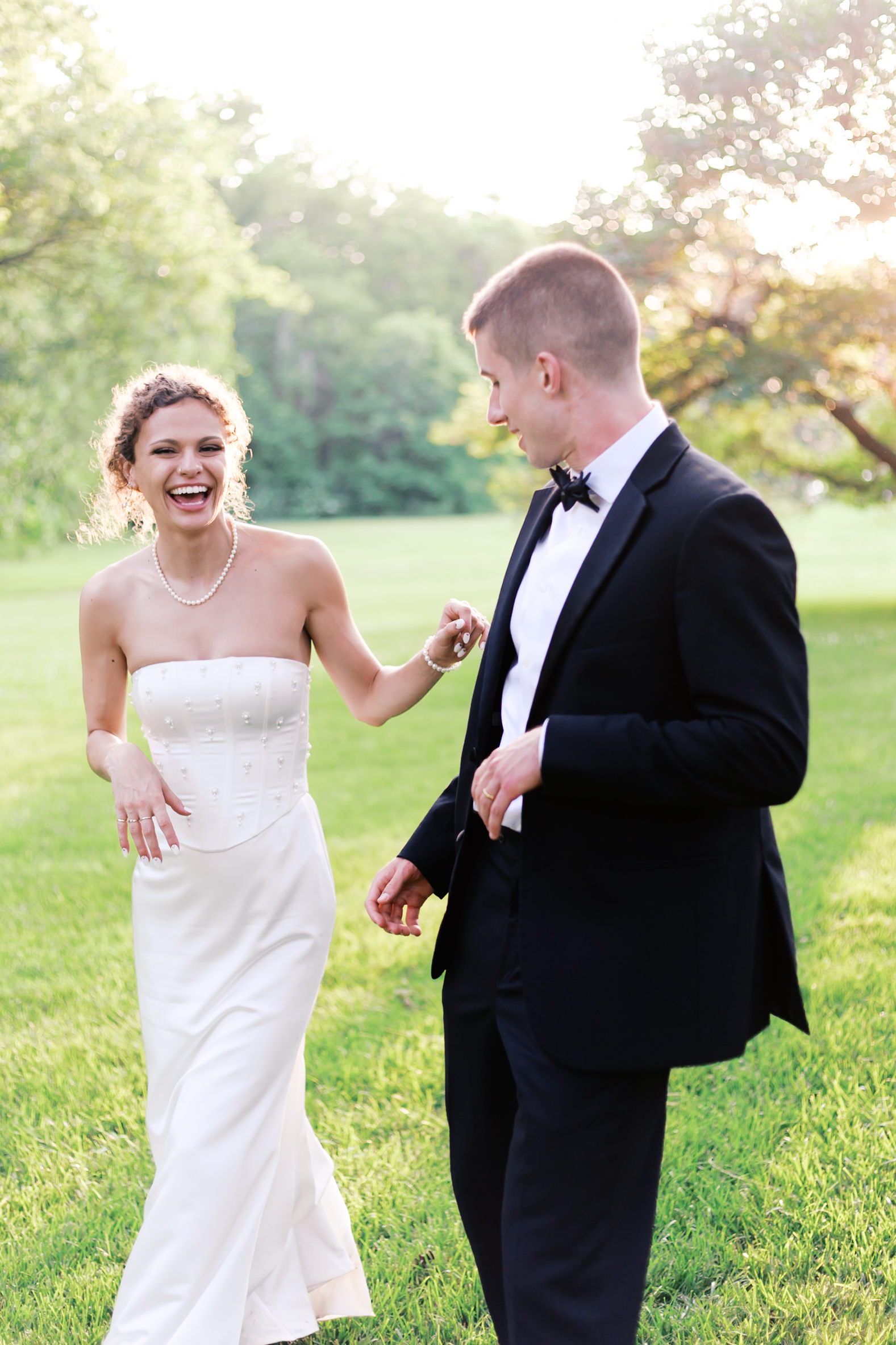 Bride laughing and reaching out for the groom as he turns to look at her.