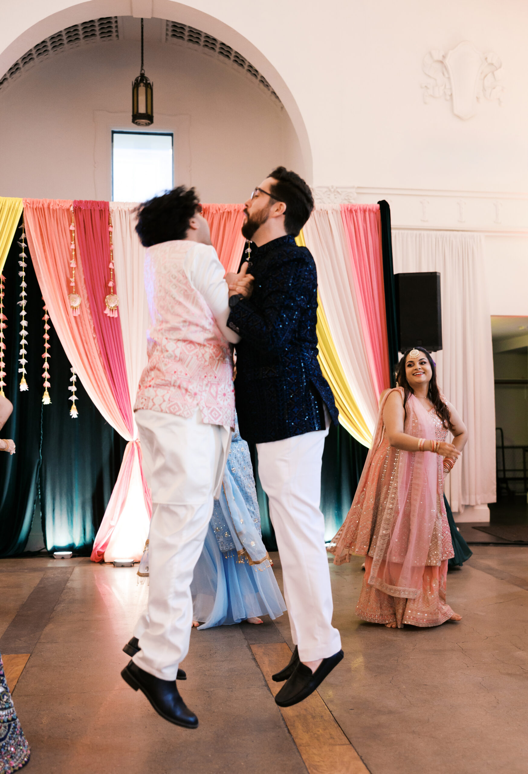 Groom lifted during energetic dance at Indian wedding celebration.