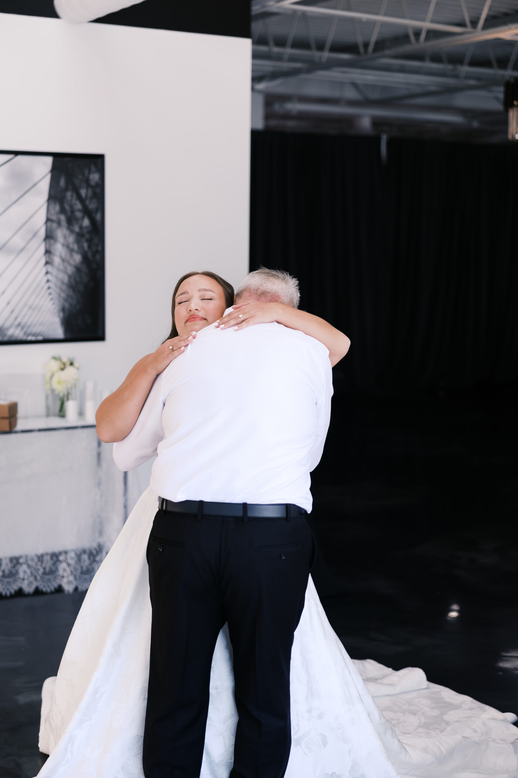Bride and her father embrace inside The Maverick during a quiet first-look moment before the ceremony.