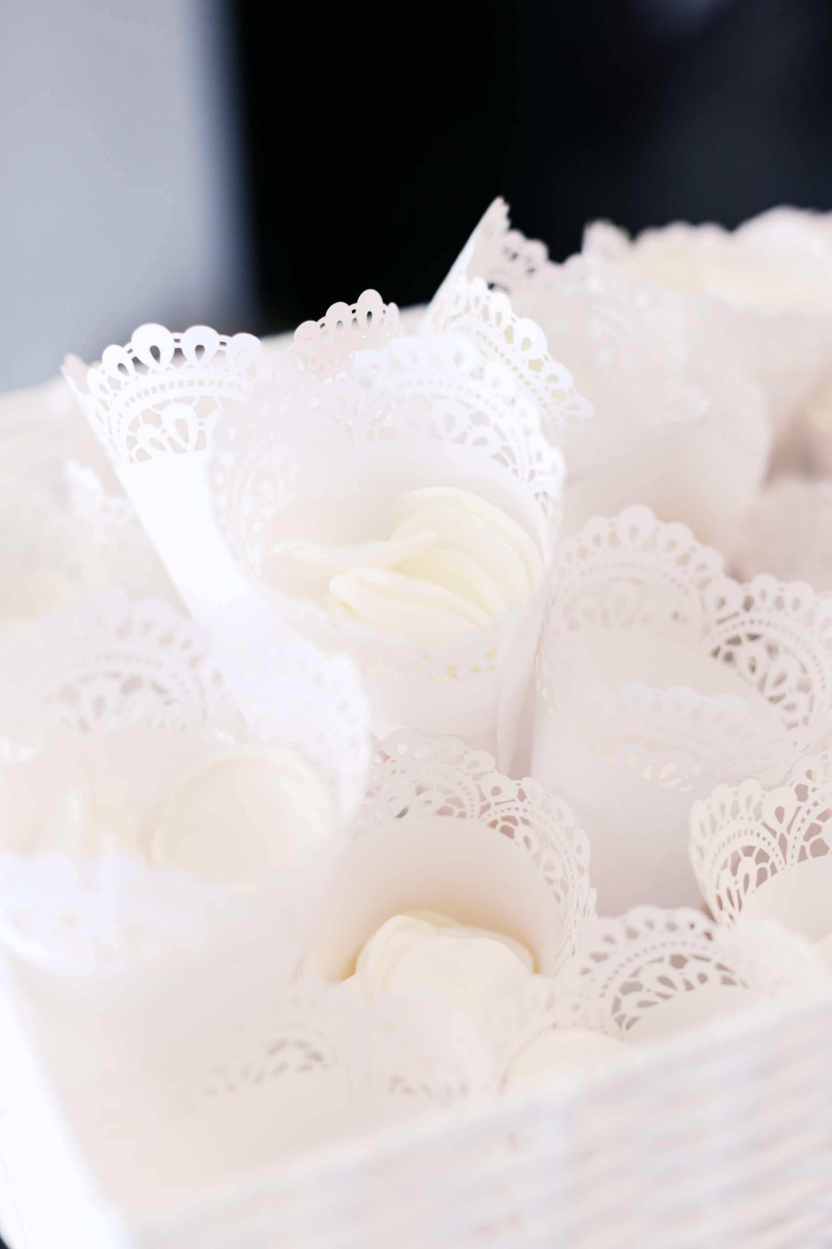 White petals in lace cones in a white basket.