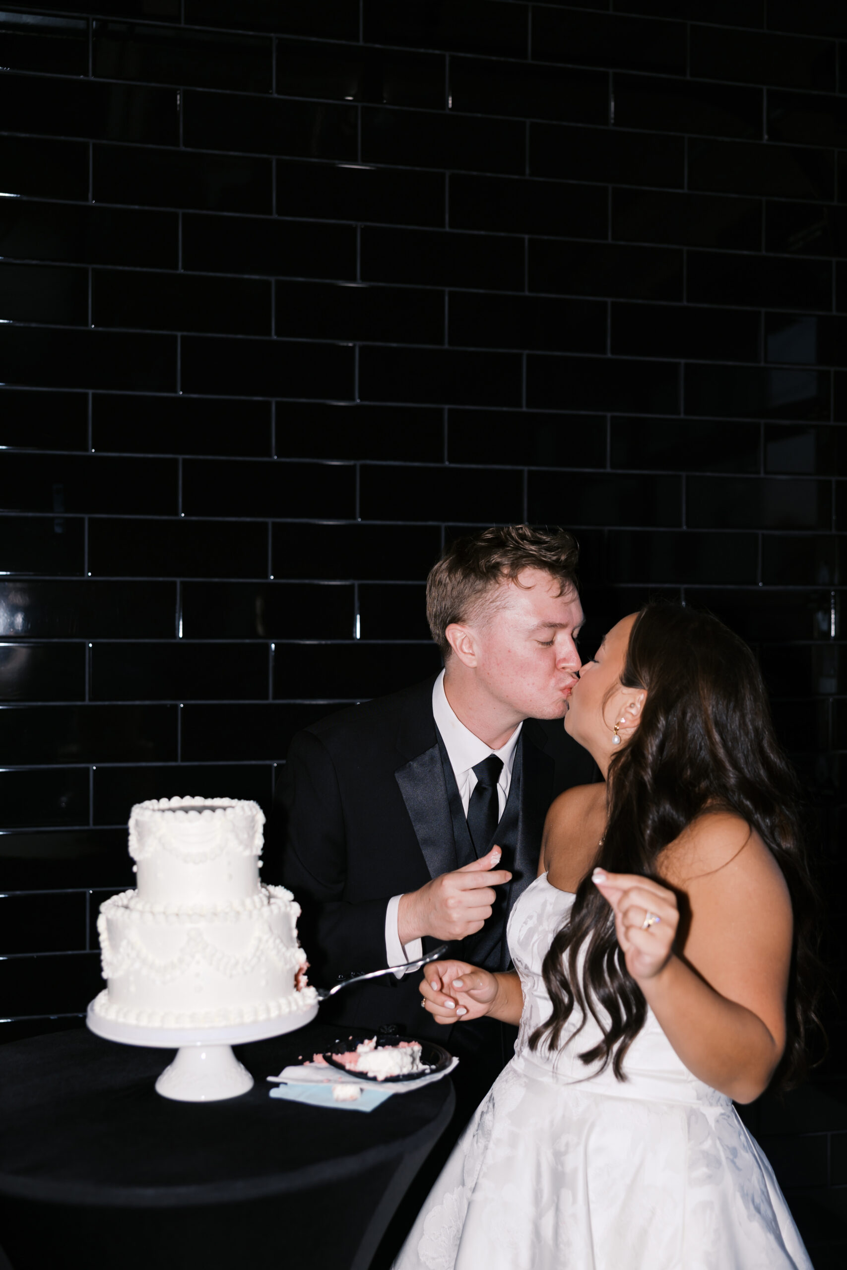 Bride and groom kissing after cutting their wedding cake.