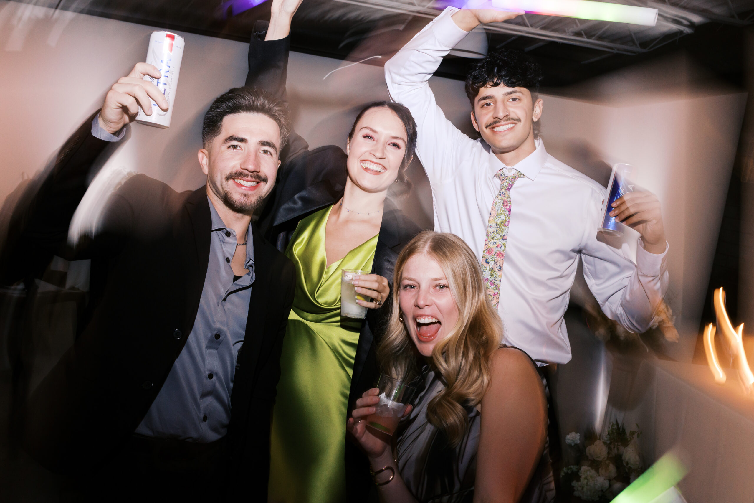 Wedding guests raising their drinks and smiling for a photo.
