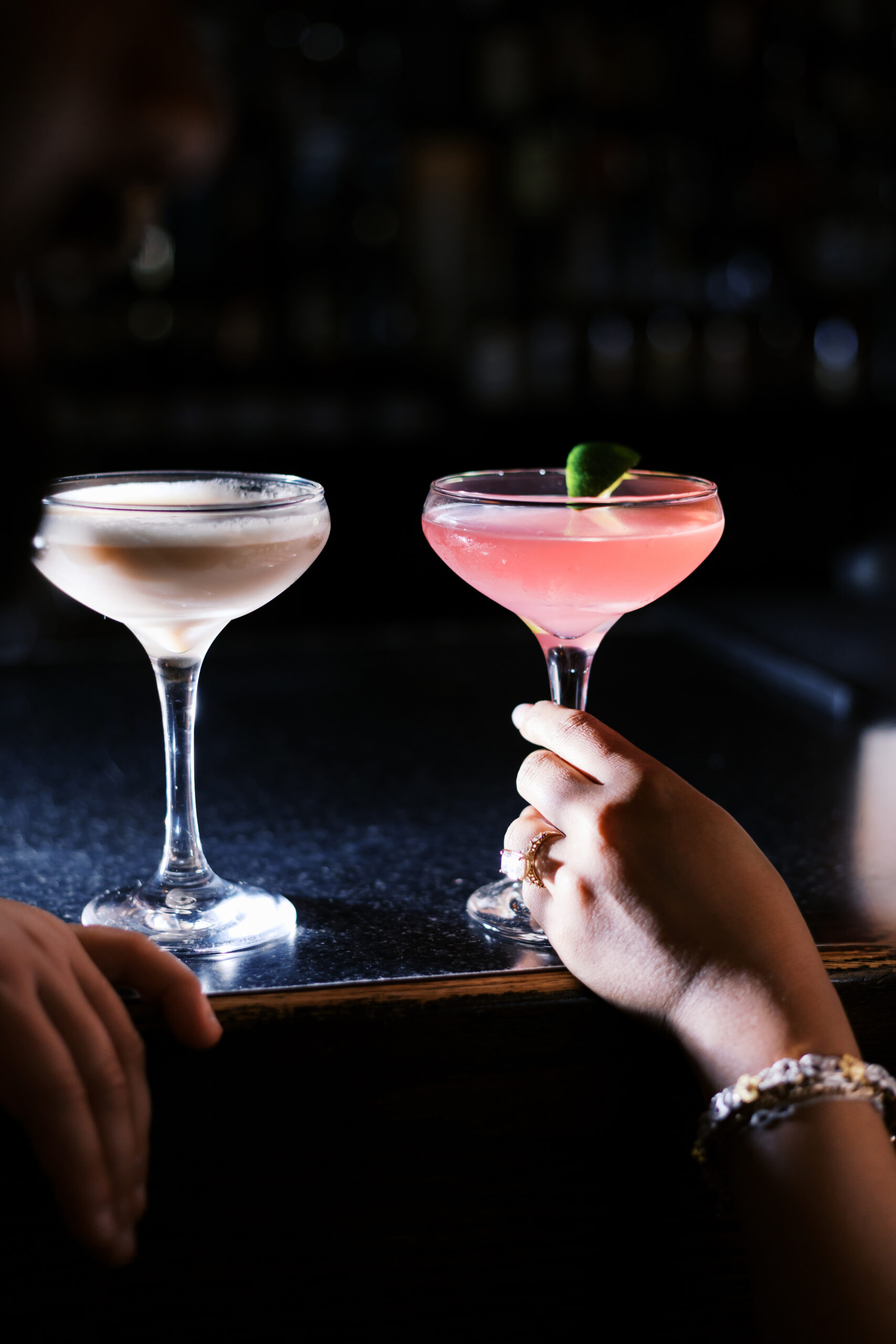 Close-up of two cocktails on a bar top during a romantic engagement session at Green Lady Lounge in downtown Kansas City.