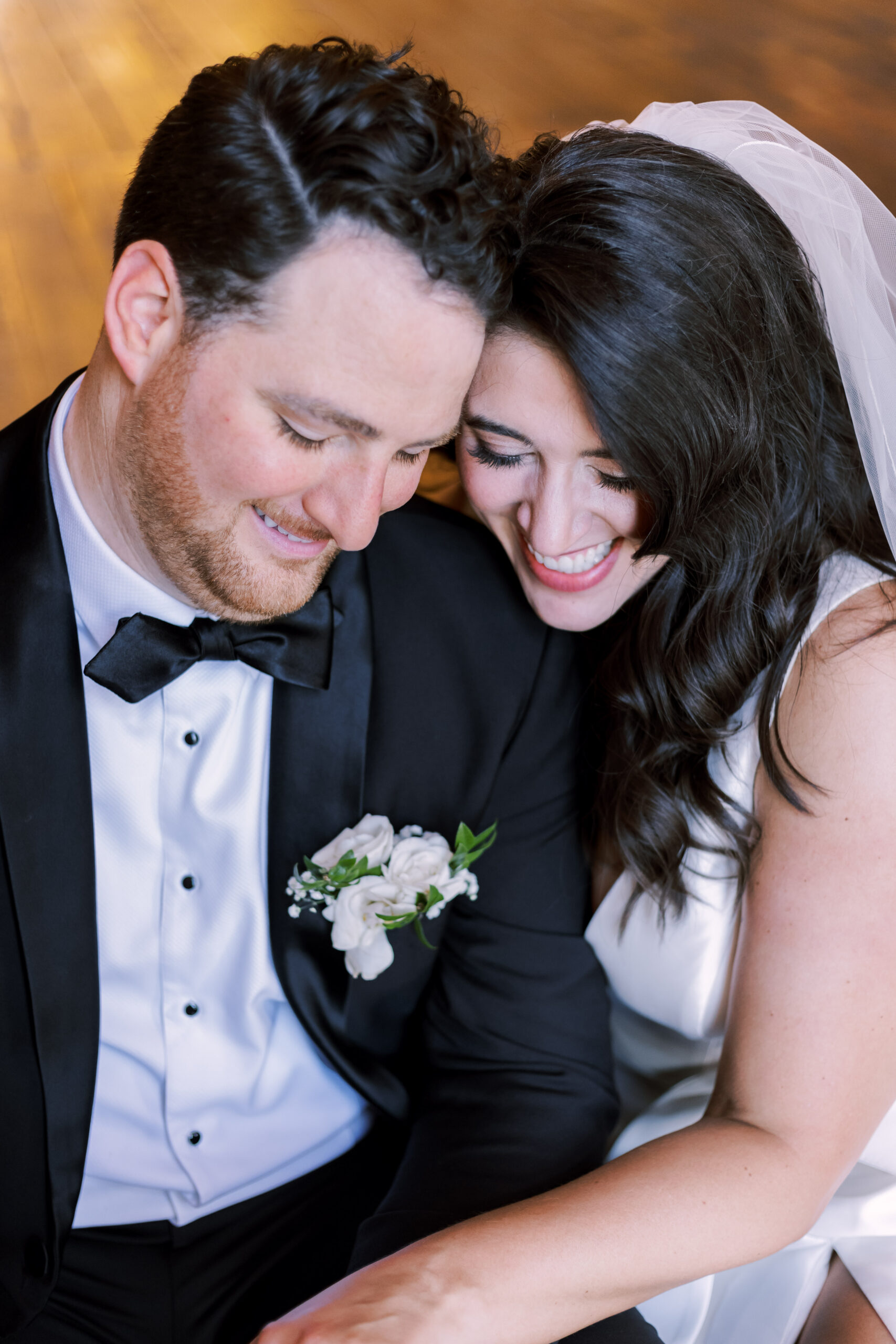 Close-up of bride and groom leaning together and smiling during a quiet moment.