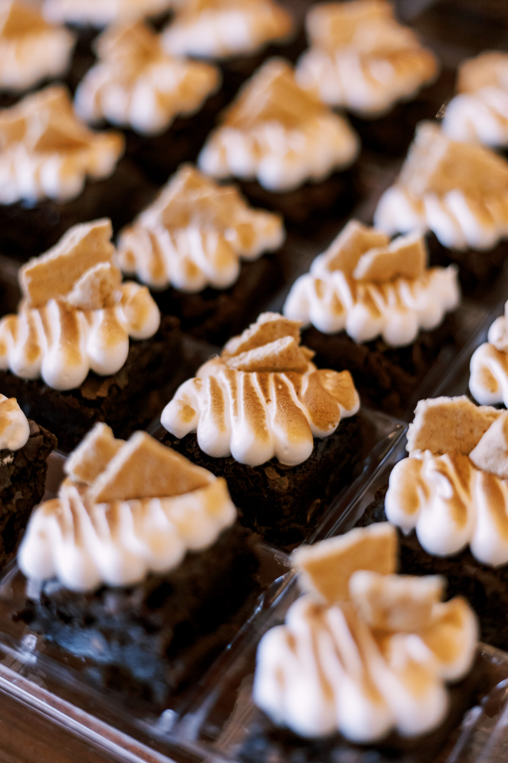 Chocolate brownie bites topped with toasted marshmallow frosting and graham cracker pieces.