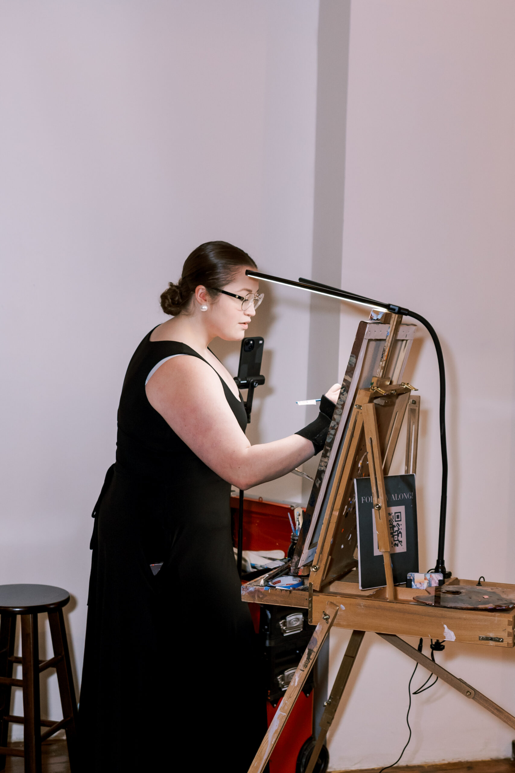 Live wedding painter creating a portrait on an easel during the reception.