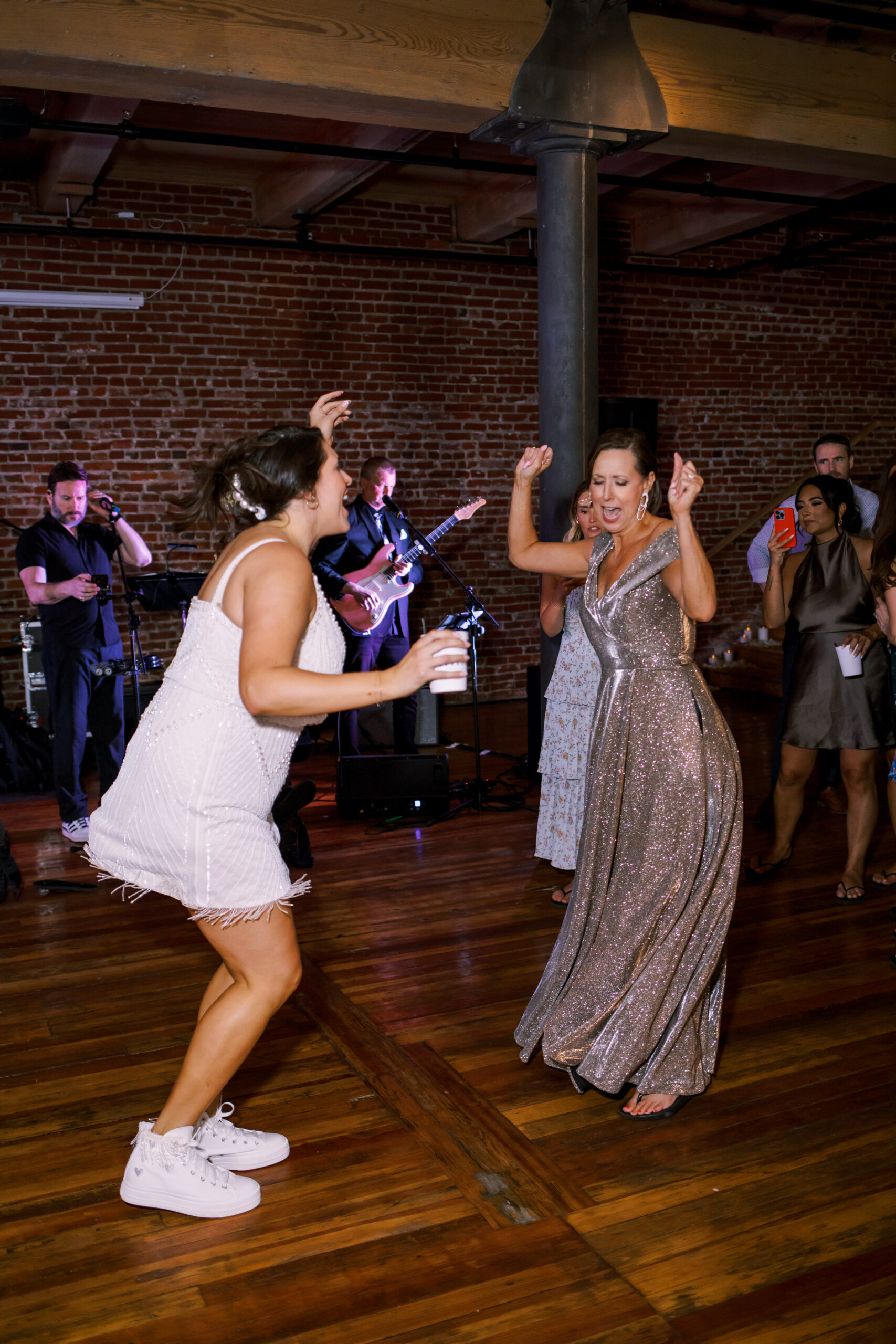 Wedding guests dancing on the reception floor while a live band performs.