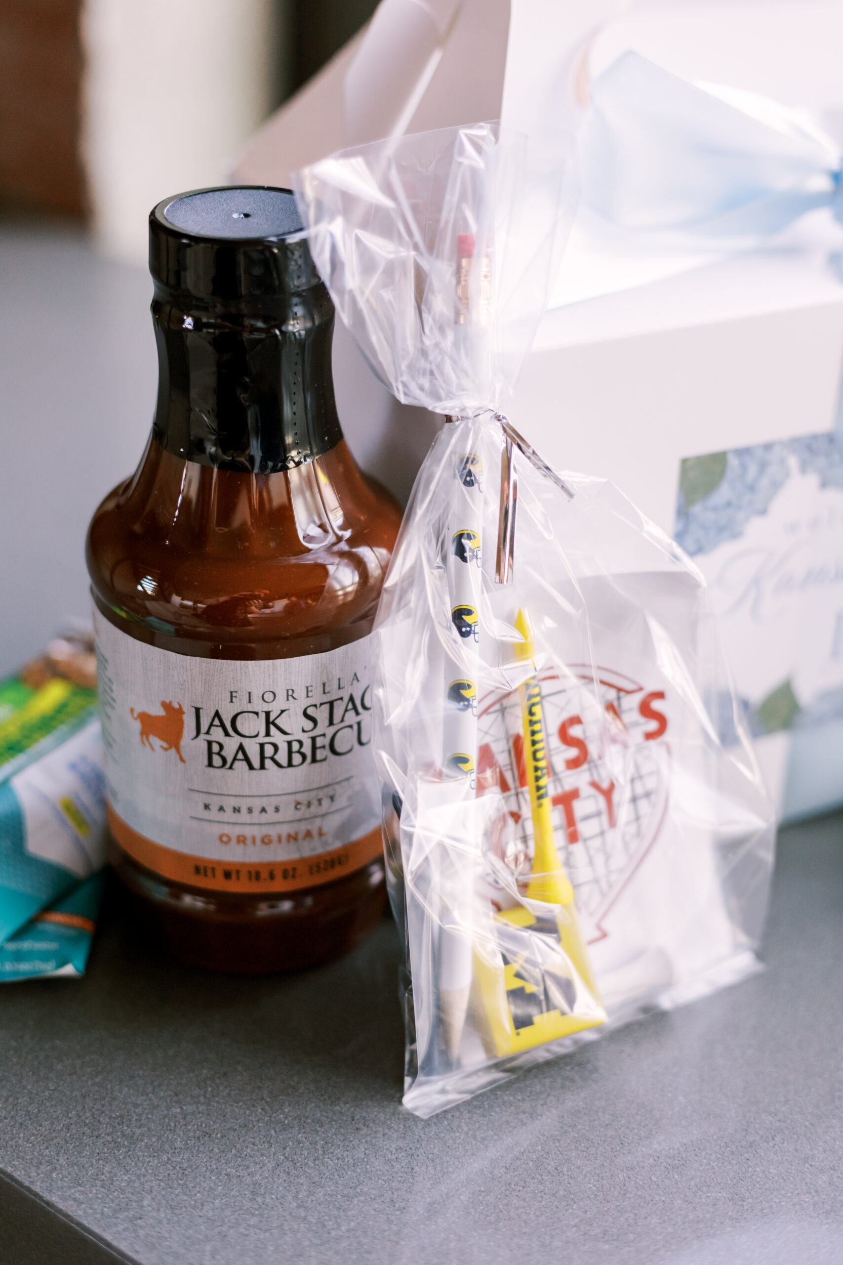 Close-up of welcome bag items including barbecue sauce, snacks, and small gifts.
