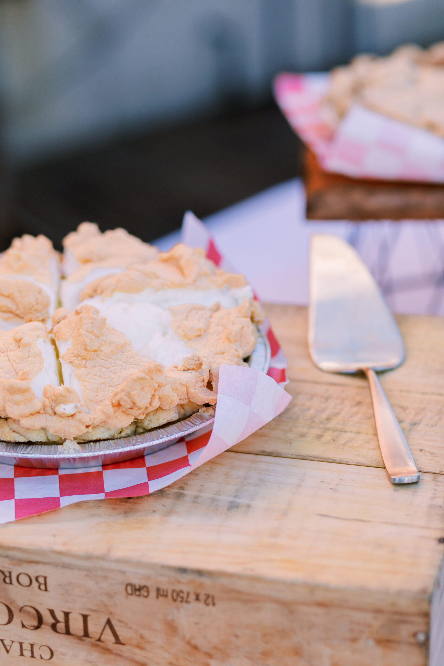 Close-up of a sliced pie on a wooden serving board with a metal pie server beside it.