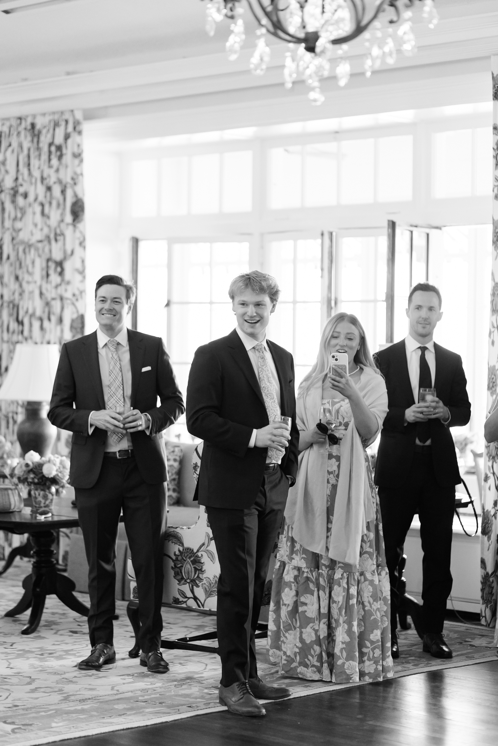 Group of guests entering reception space, dressed in formal attire