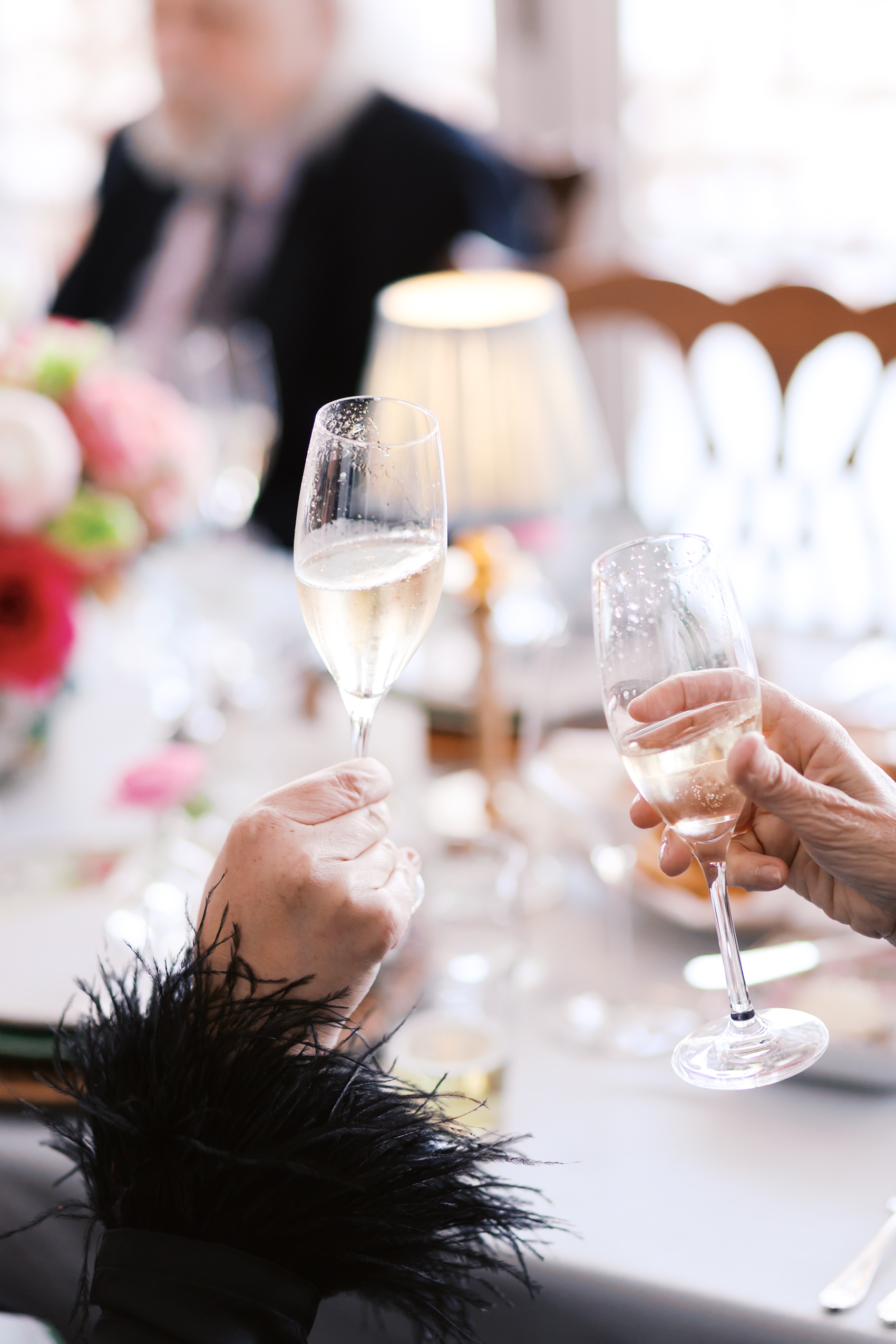 Guests toasting with champagne glasses at elegantly decorated reception table