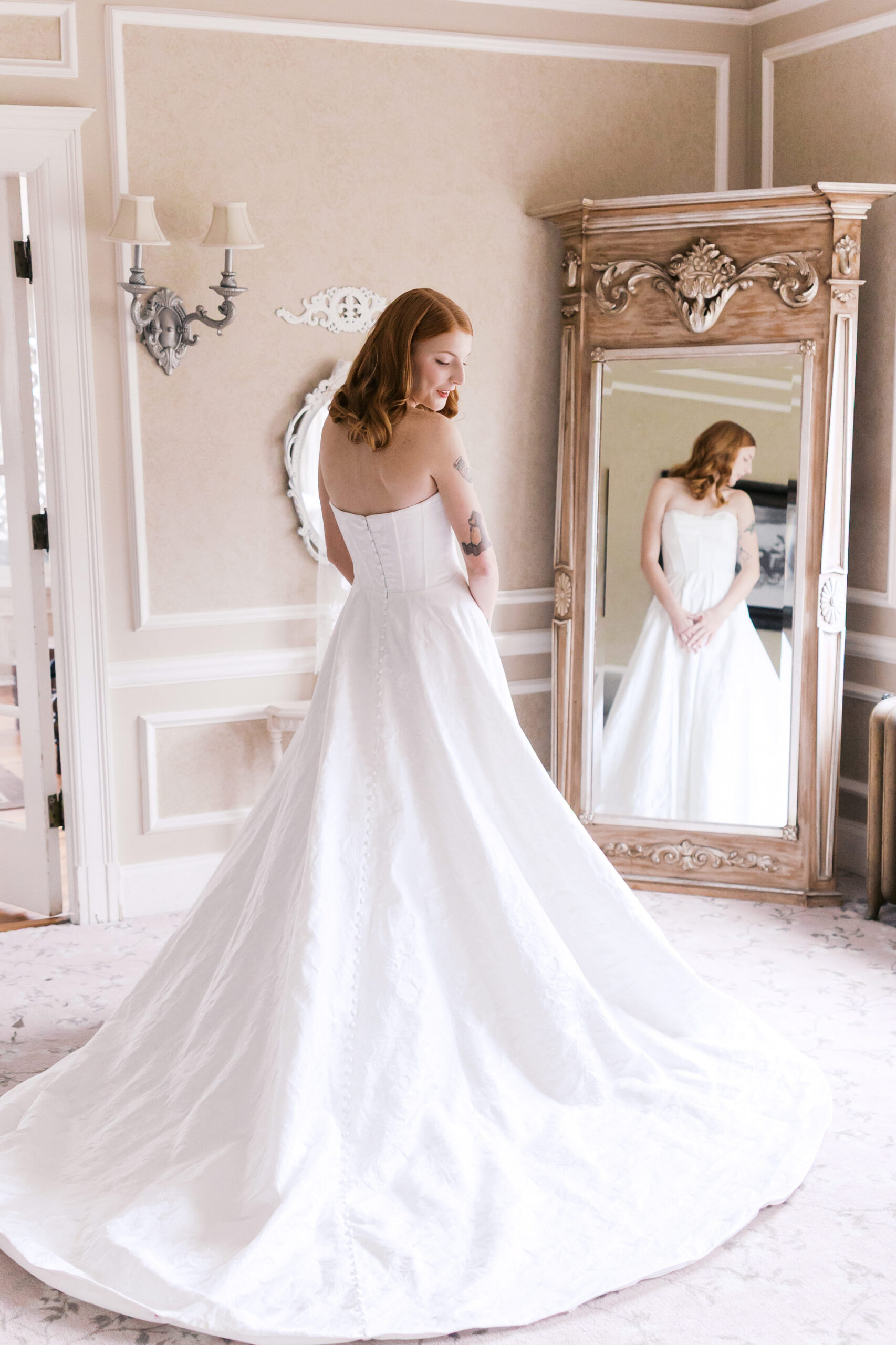 Full-length bridal portrait with flowing gown and mirror reflection inside Longview Mansion