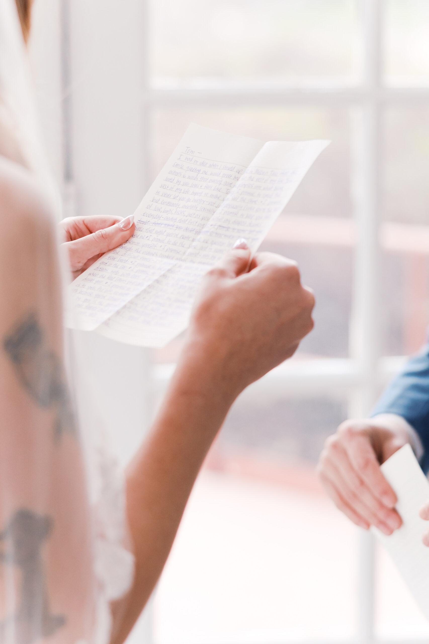 Close-up of handwritten wedding vows held by bride during ceremony