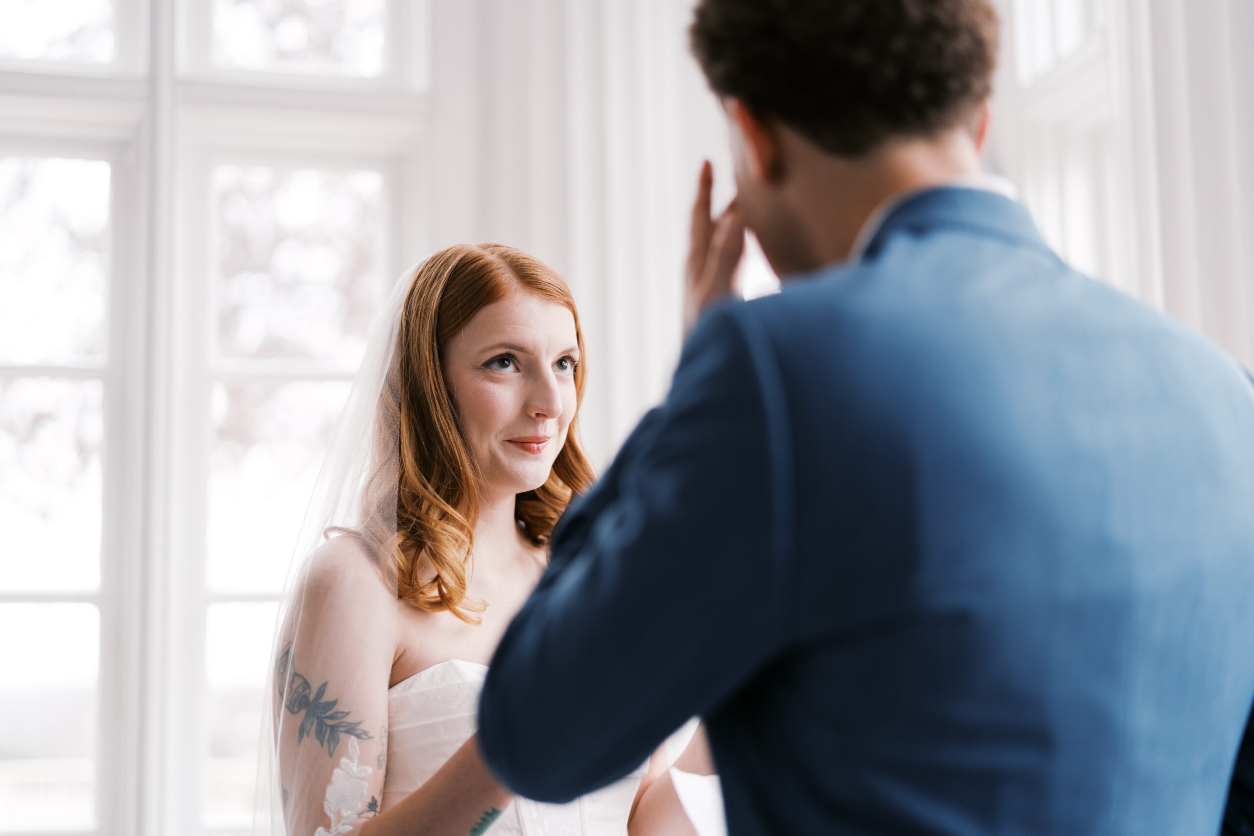 Groom reacting emotionally while reading vows to bride indoors