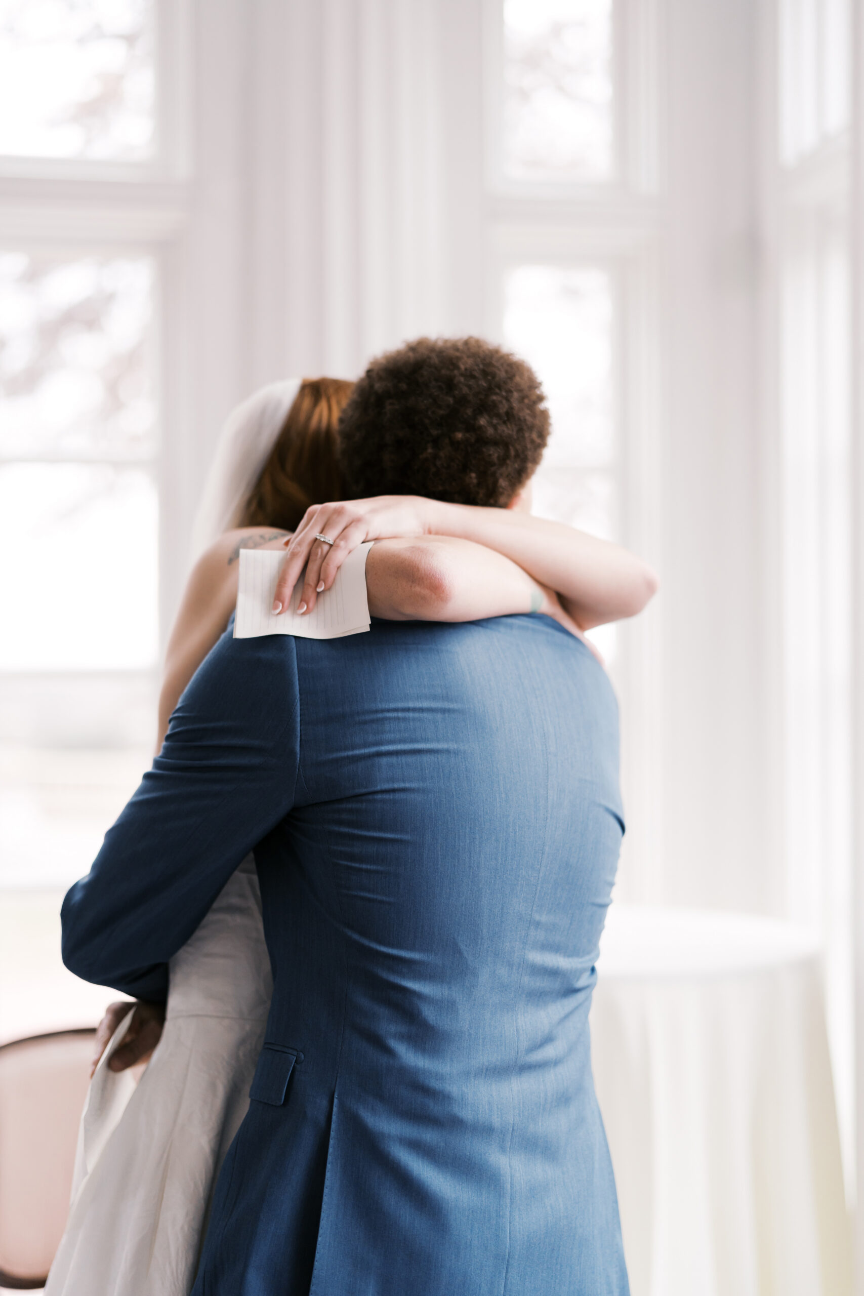 Couple embracing after vows in bright indoor wedding setting