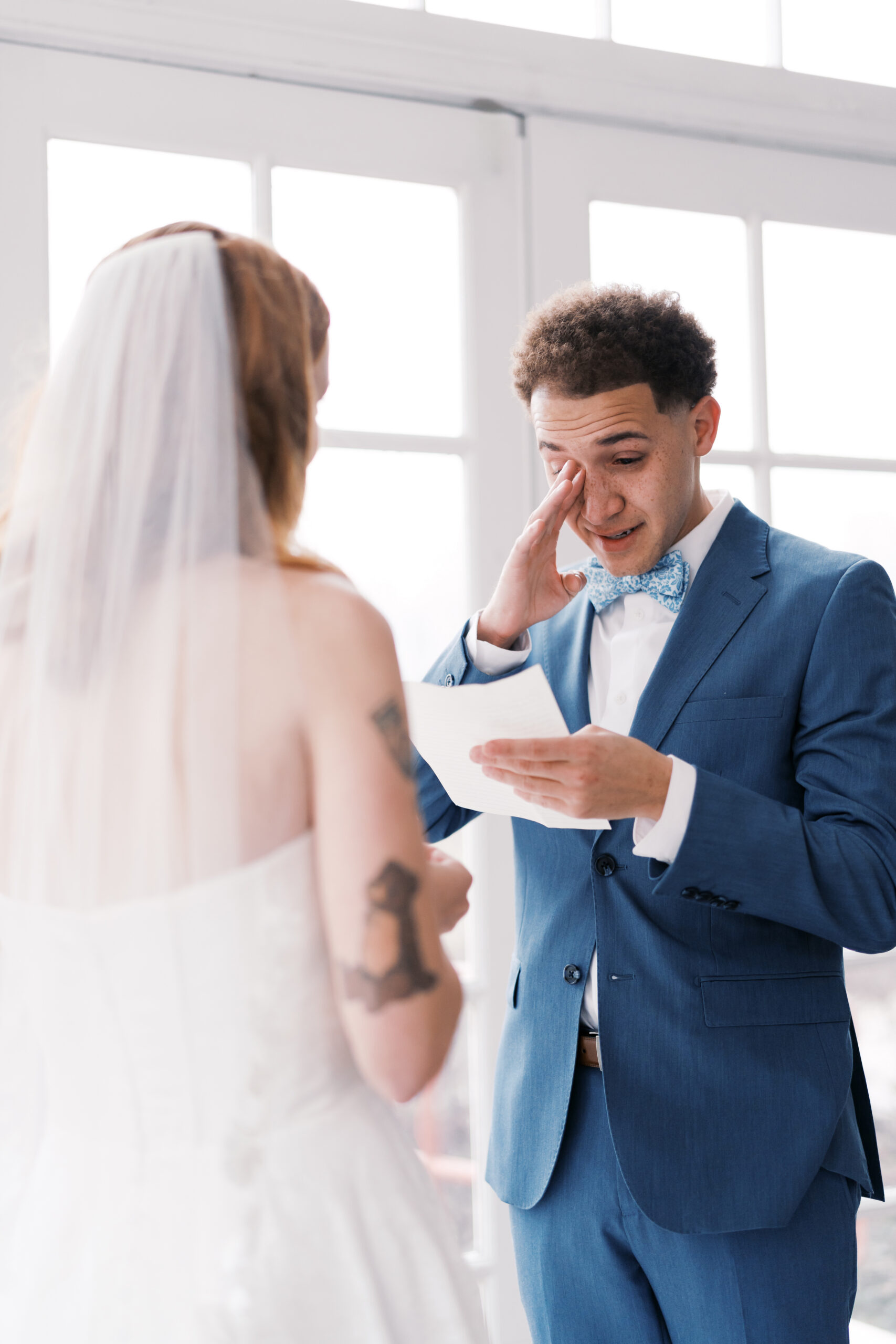 Groom wiping tears while reading vows to bride at Longview Mansion