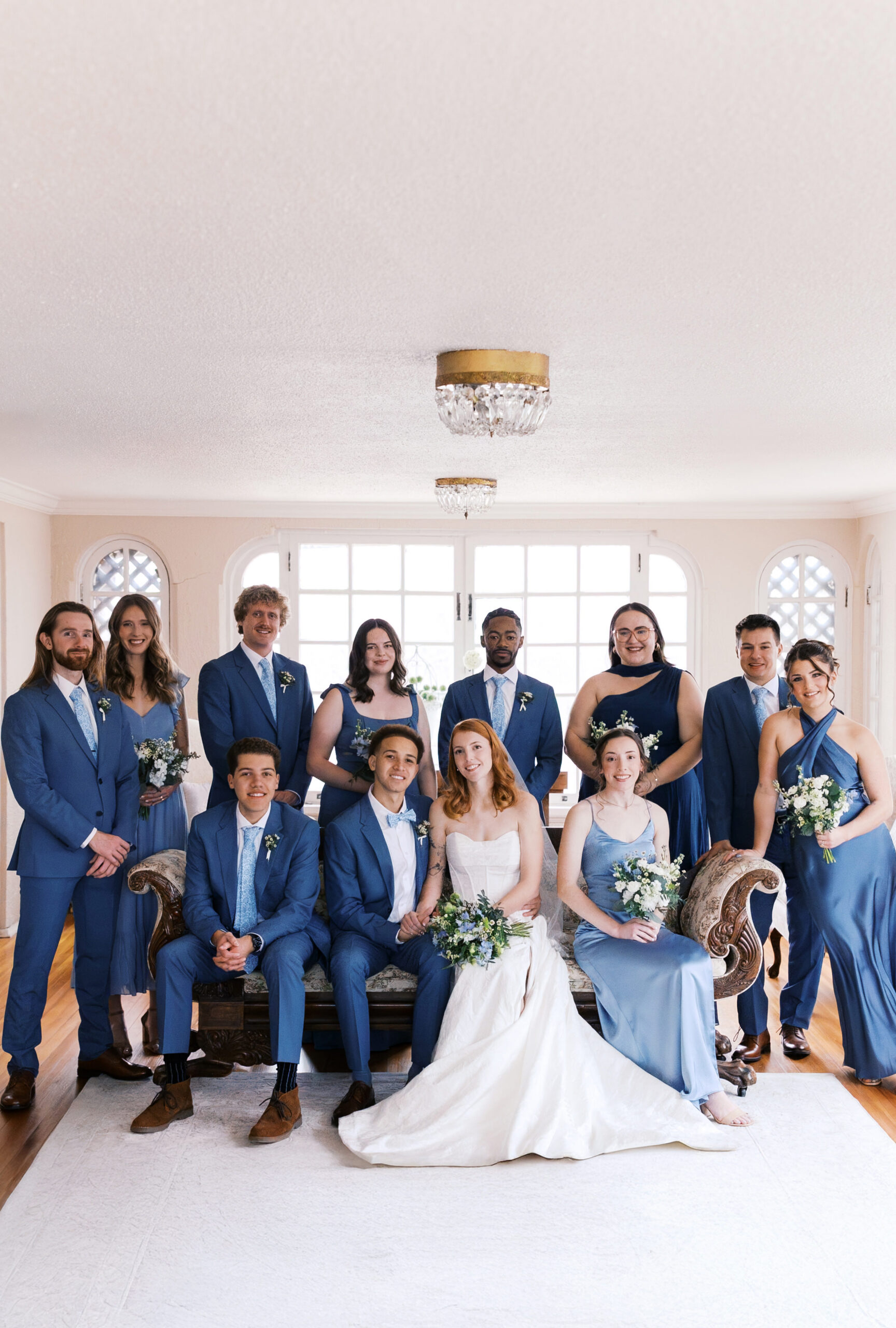 Full wedding party portrait indoors with bride and groom centered