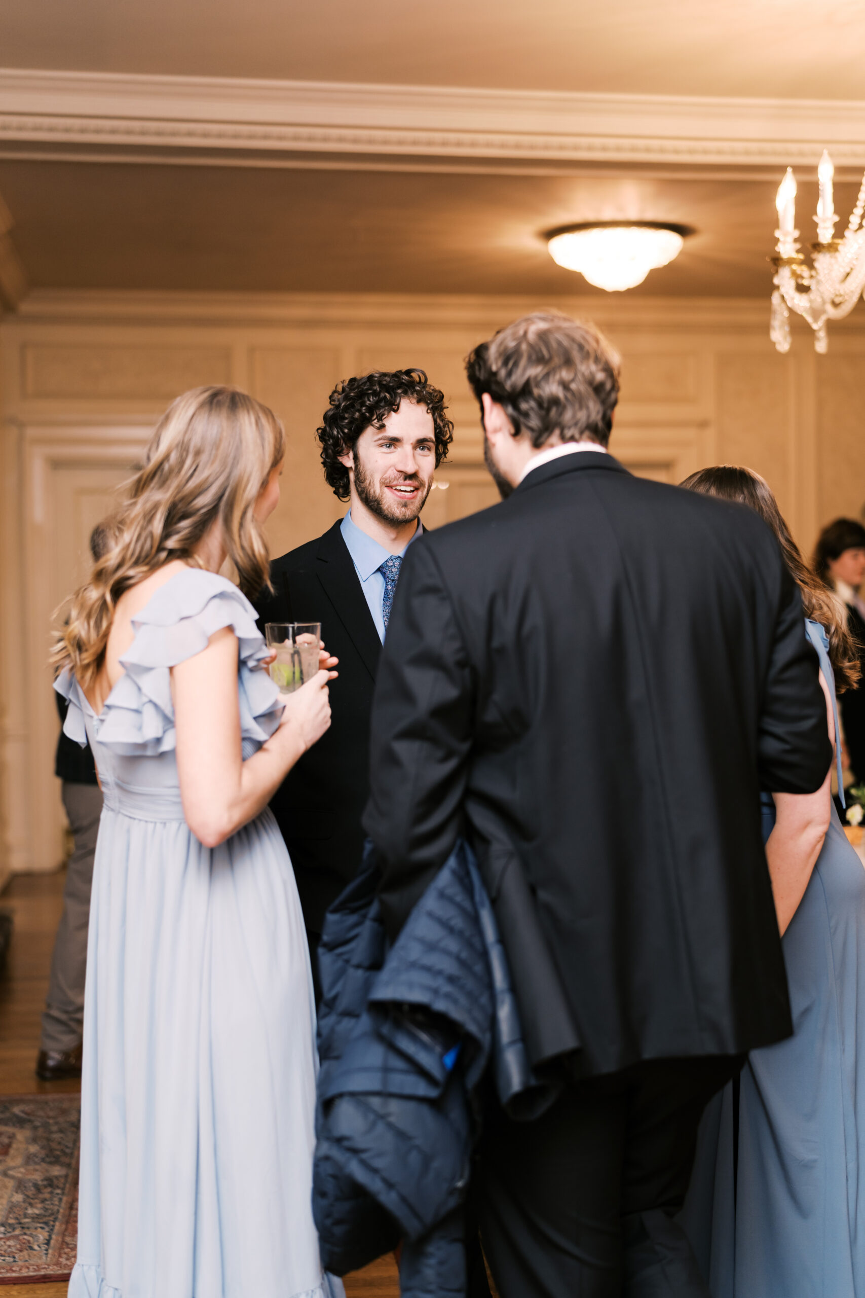 Group of four guests converse during cocktail hour.