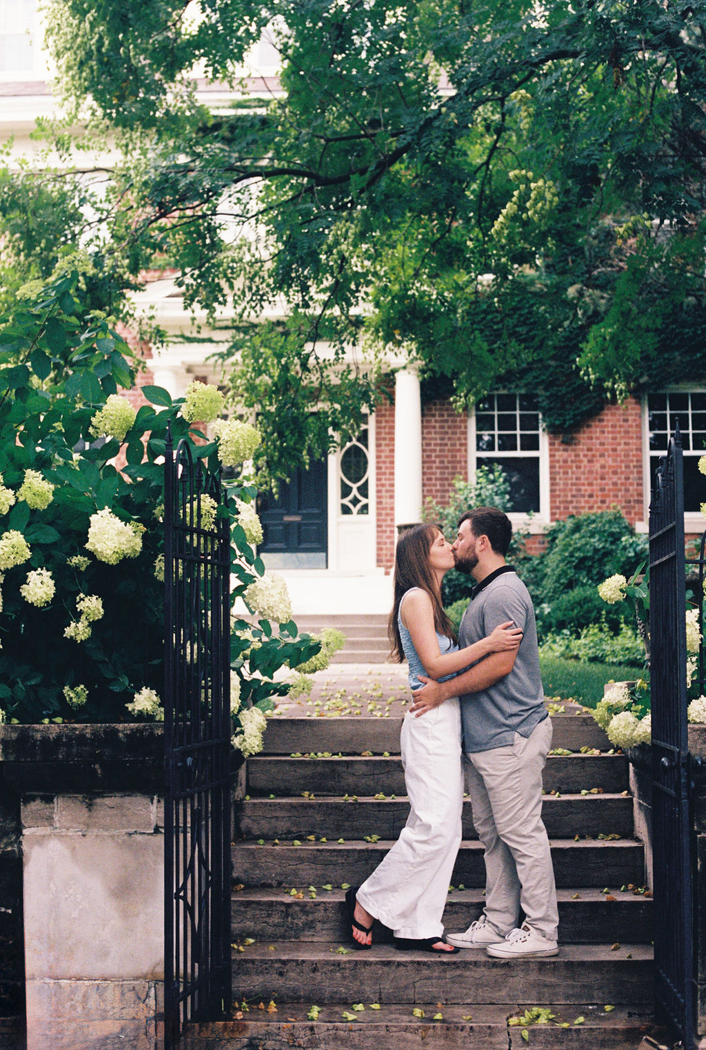 Engaged couple kissing at the garden entrance of The Truitt during an engagement session.