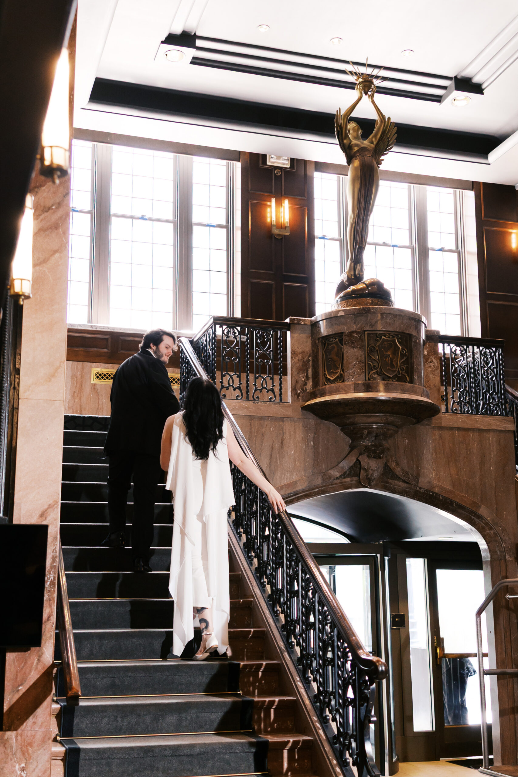 Couple walking up the grand staircase at Hotel Phillips in Kansas City.