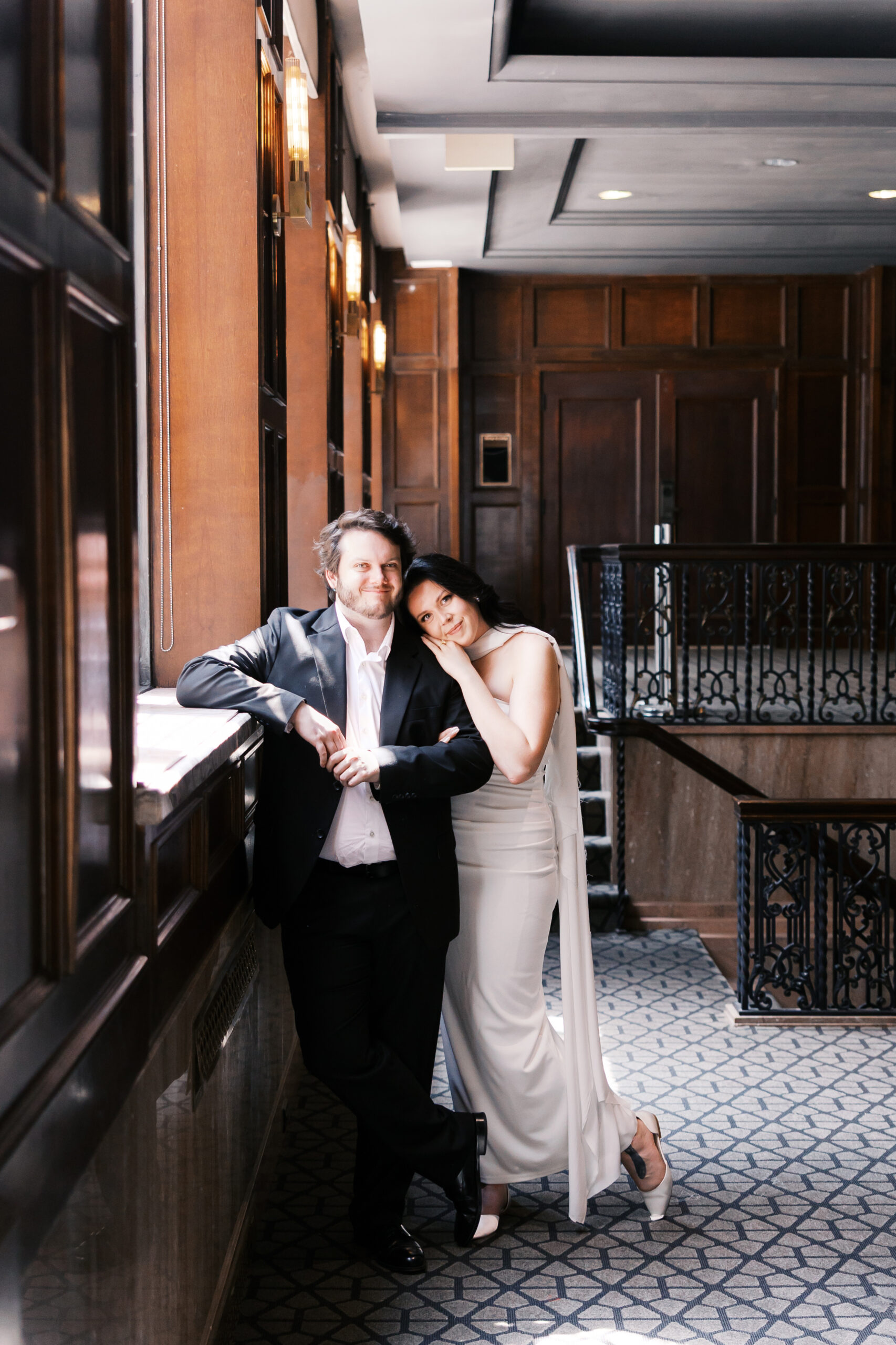 Full-length portrait of the couple embracing in a bright hallway at Hotel Phillips.