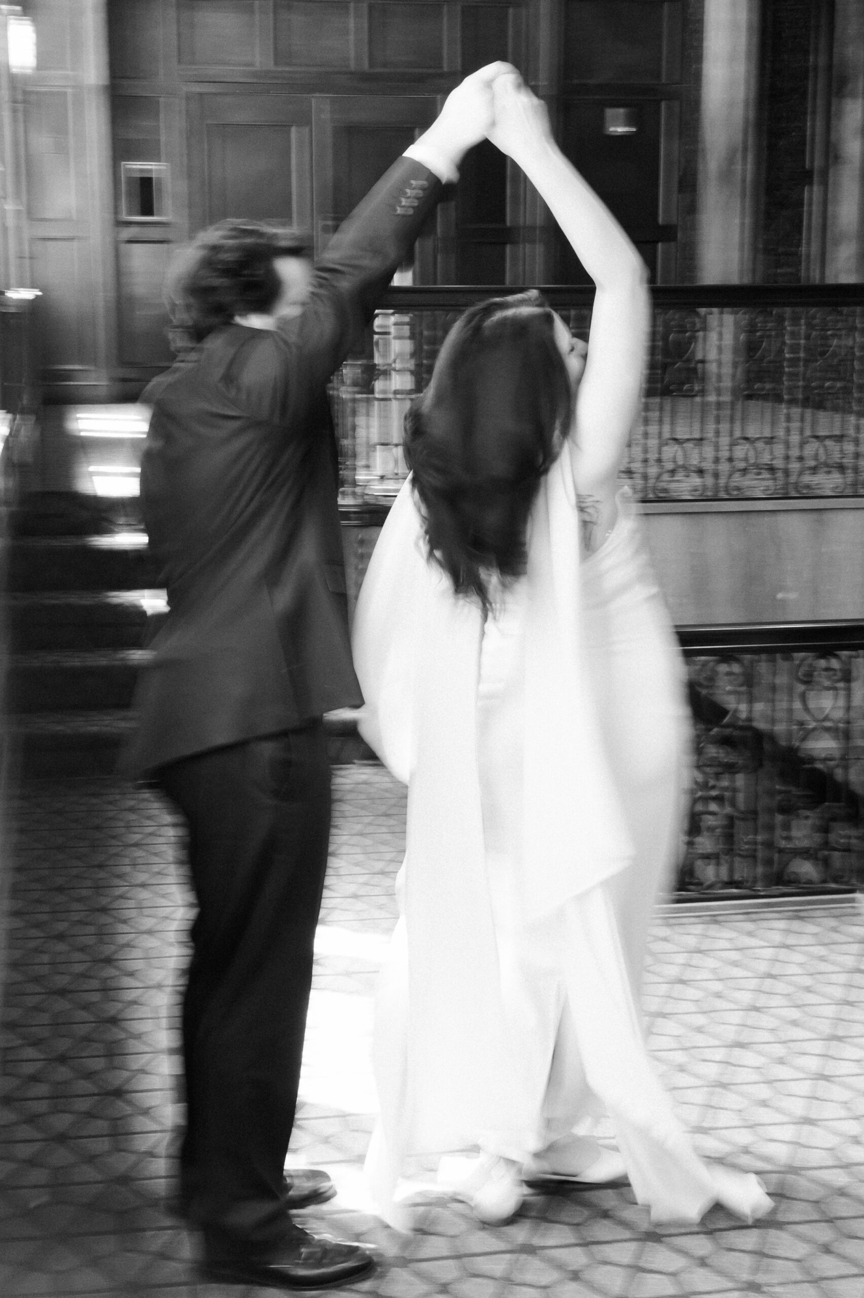 Black-and-white motion blur of the couple dancing together in the hotel lobby.
