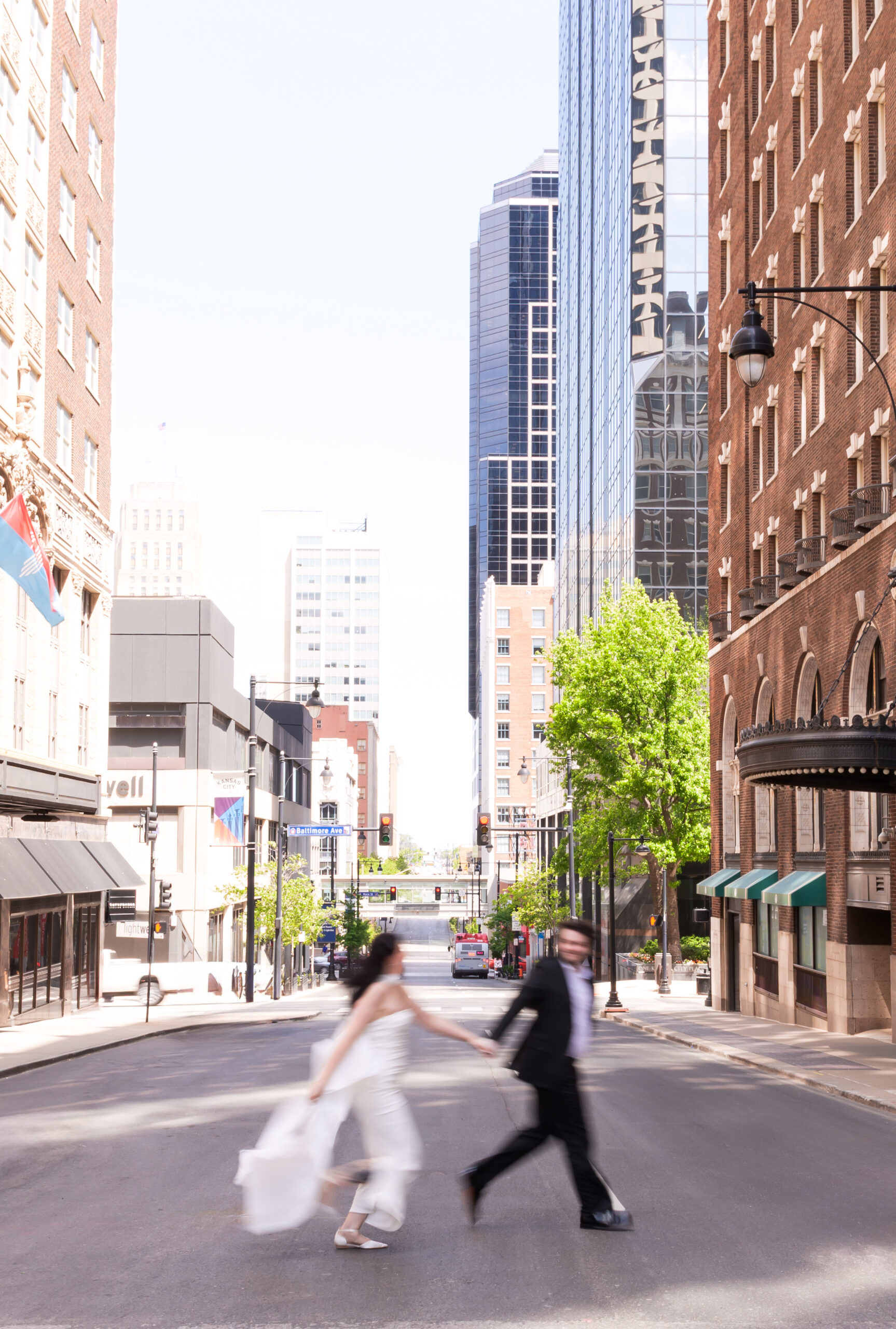 Motion-blur photo of the couple holding hands while crossing a downtown Kansas City street.